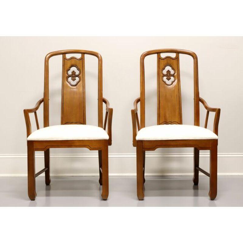 A pair of Asian inspired dining armchairs by Thomasville, from their Mystique Collection. Solid walnut with upholstered seats in a neutral cream fabric. Features carved center backs, curved arms, Asian style apron, legs and feet with stretchers.