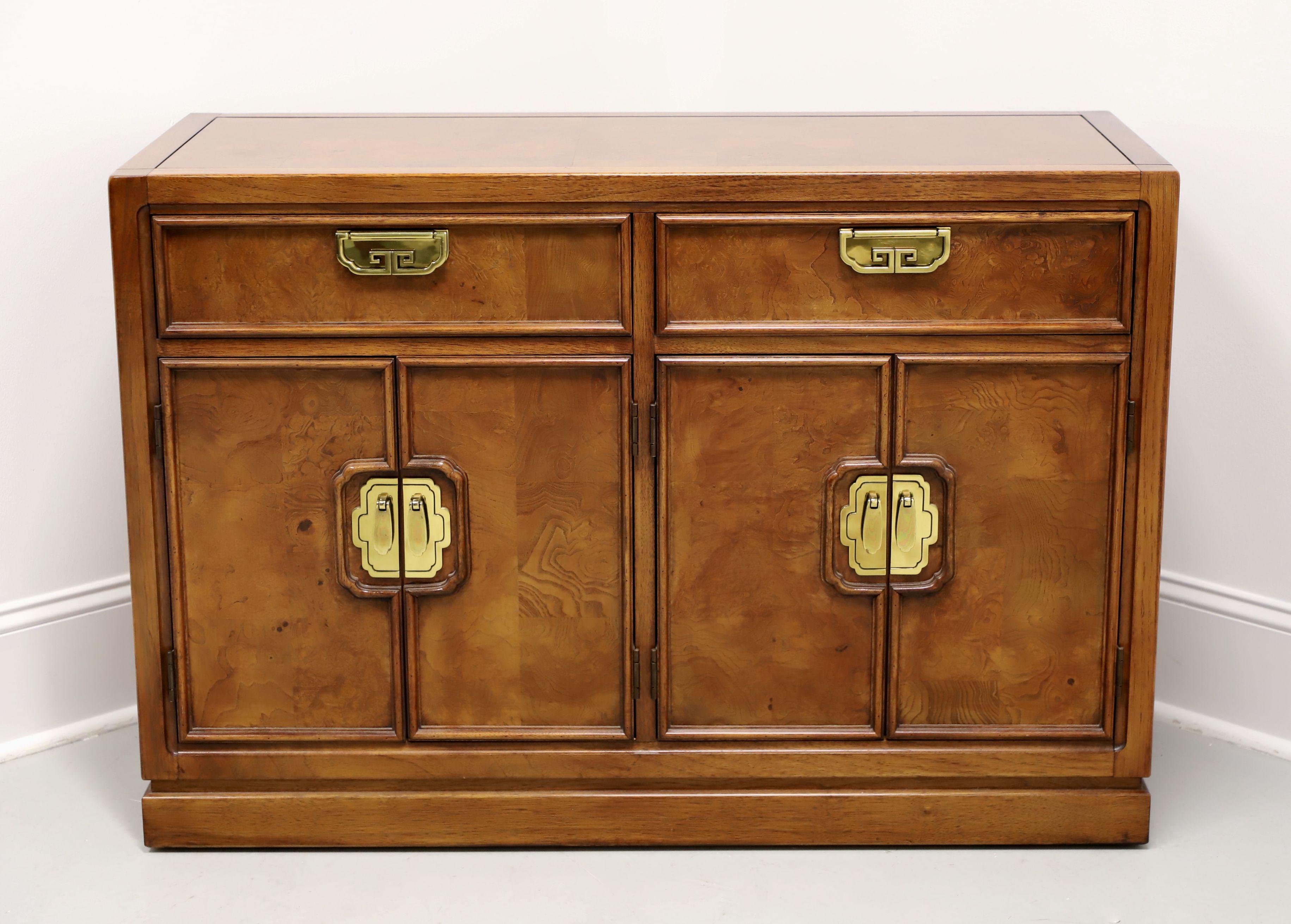 An Asian inspired console cabinet by Thomasville, from their Mystique Collection. Solid walnut with inlaid burl walnut, decorative brass hardware, banded burl walnut top with smooth square edge, inlaid burl walnut drawer & door panels, and a solid