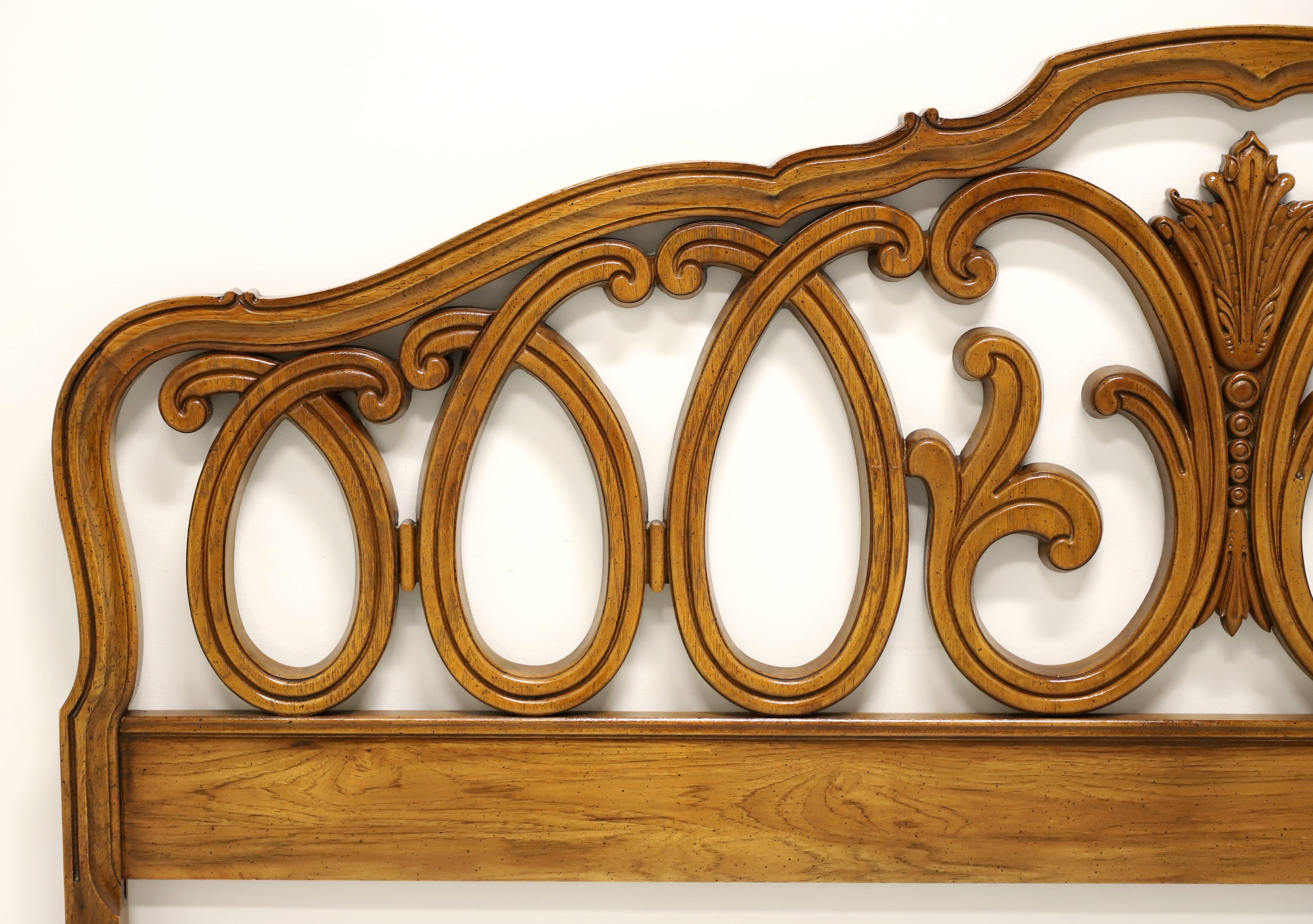 A French Country style king size headboard by Thomasville. Solid pecan, or similar nutwood, with arched top, decorative open carvings, and center carved foliate sheaf. Made in Thomasville, North Carolina, USA, circa 1971.

Style #: 