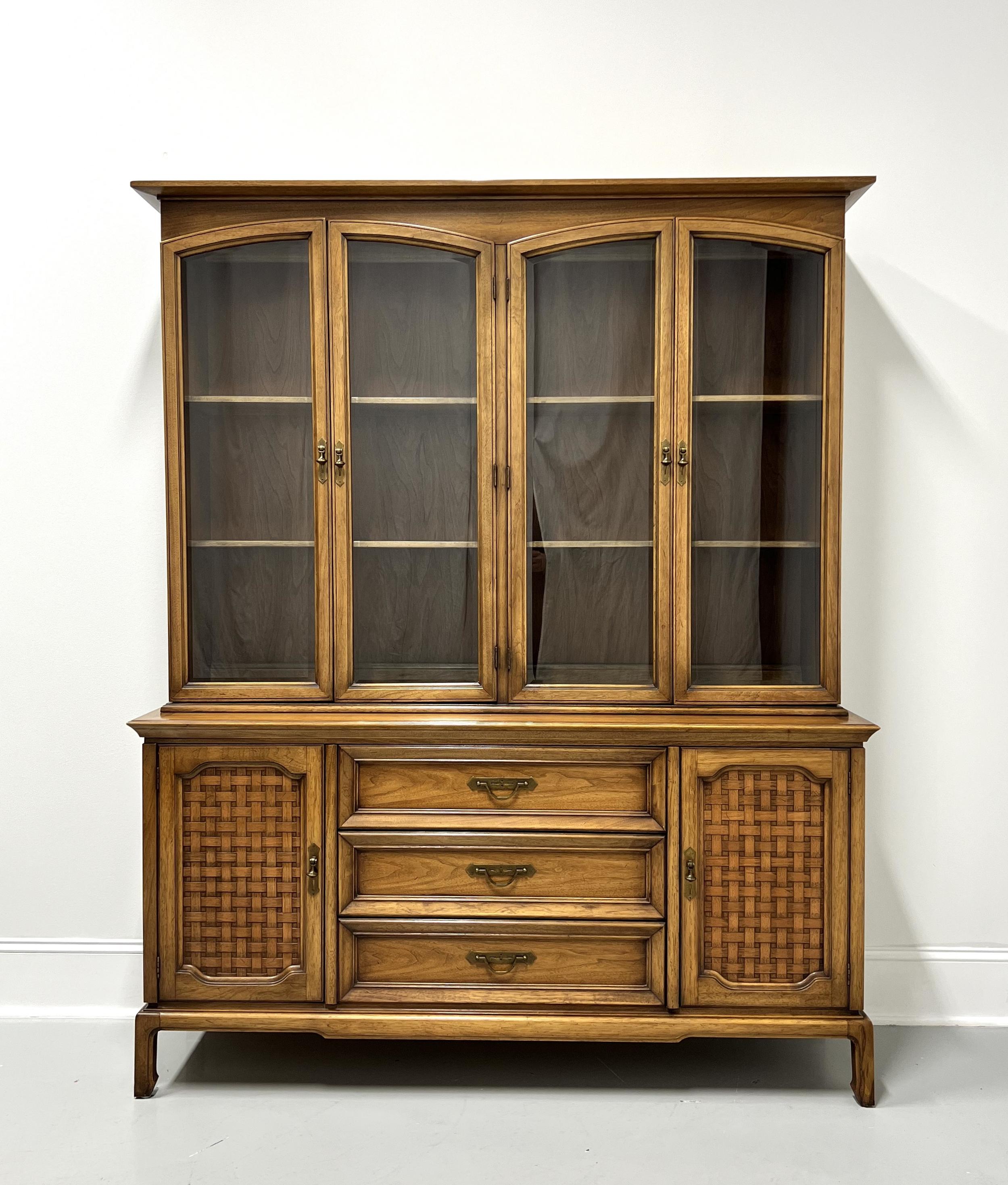 A Mid 20th Century Modern MCM style china cabinet by Thomasville. Pecan, or similar nutwood, with brass hardware, crown molding to top, arched upper cabinet single pane glass doors, ogee edge to top of lower cabinet, raised drawer fronts, basket