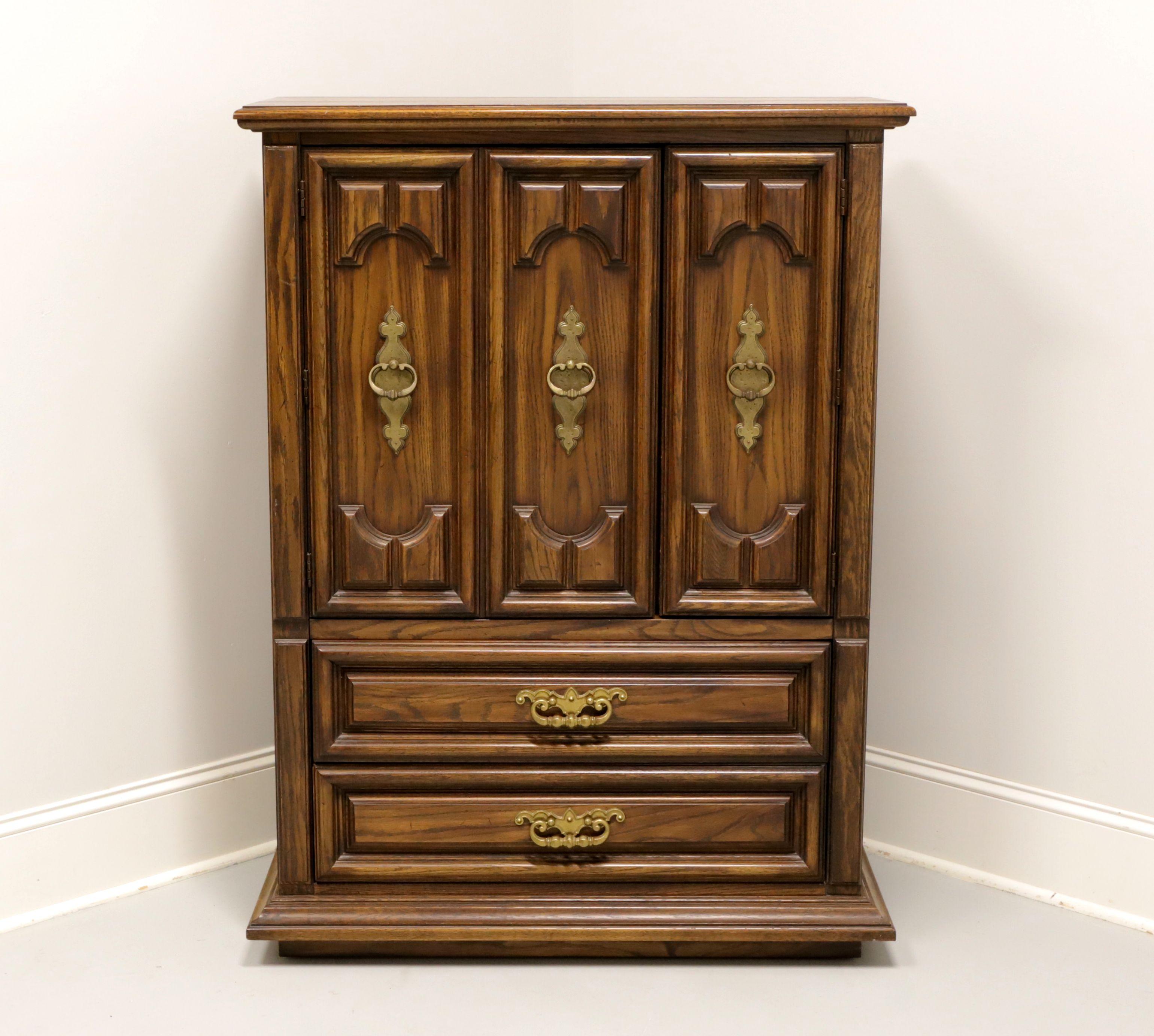 A Spanish Mediterranean style gentleman's chest by Thomasville, from their Segovia Collection. Solid oak with slightly distressed finish, bevel edge top, brass hardware, raised door & drawer fronts, and a solid base. Upper cabinet features triple