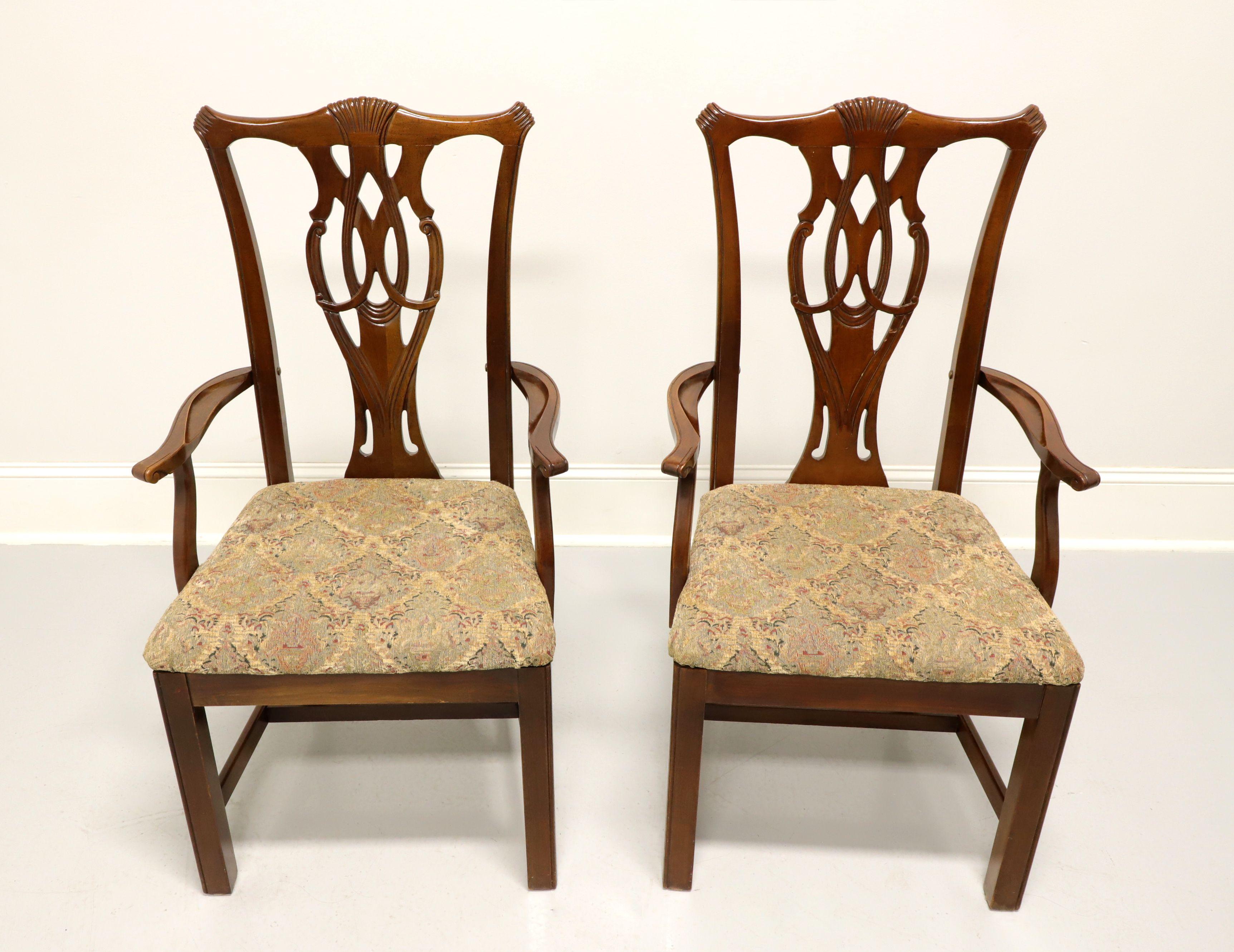 A pair of dining armchairs in the Chippendale style by Thomasville. Solid cherry with carved crest rail, carved seat back, curved arms, multi-color pattern fabric upholstered seat, straight legs and stretchers. Made in Thomasville, North Carolina,