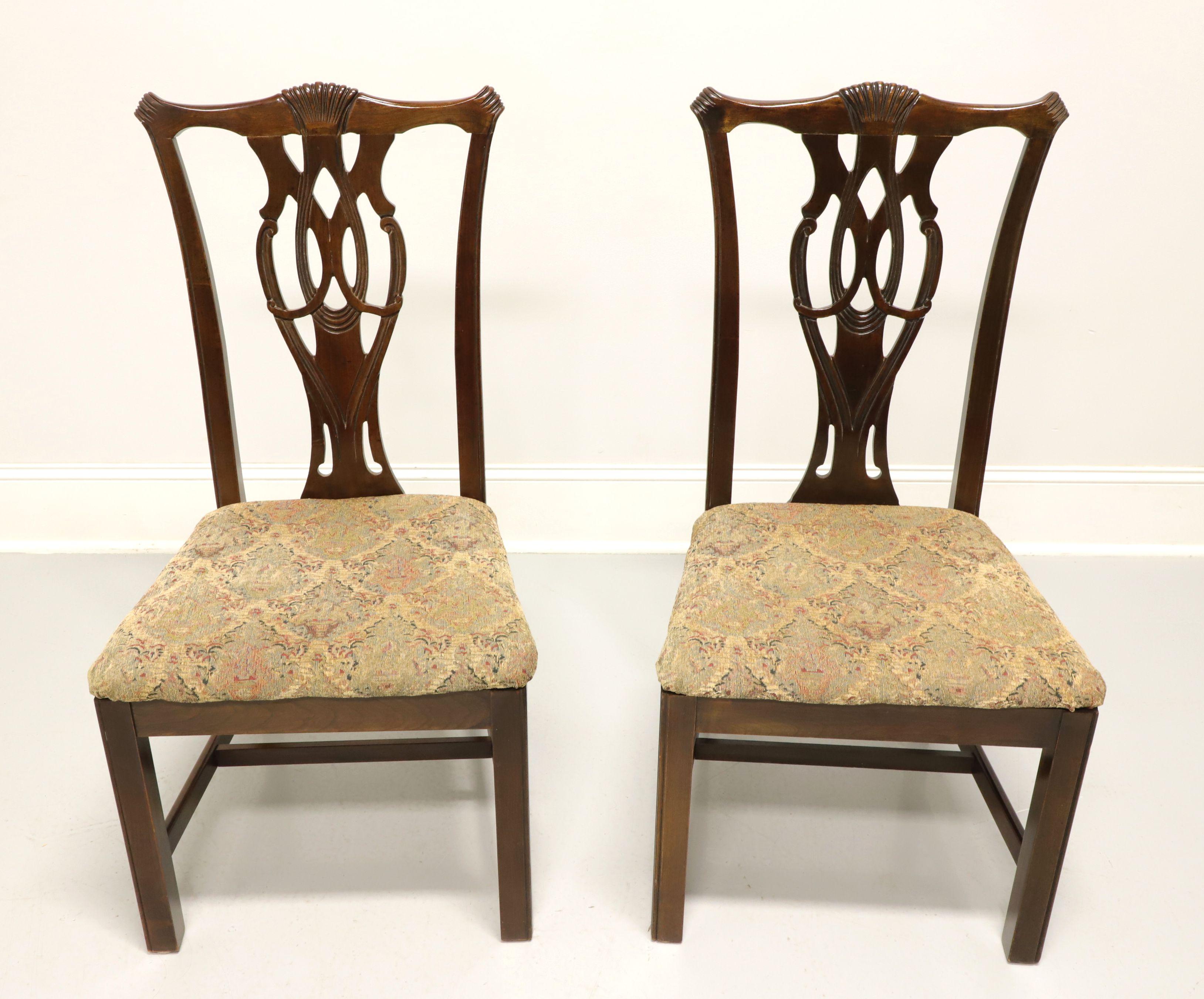 A pair of dining side chairs in the Chippendale style by Thomasville. Solid cherry with carved crest rail, carved seat back, multi-color pattern fabric upholstered seat, straight legs and stretchers. Made in Thomasville, North Carolina, USA, in the