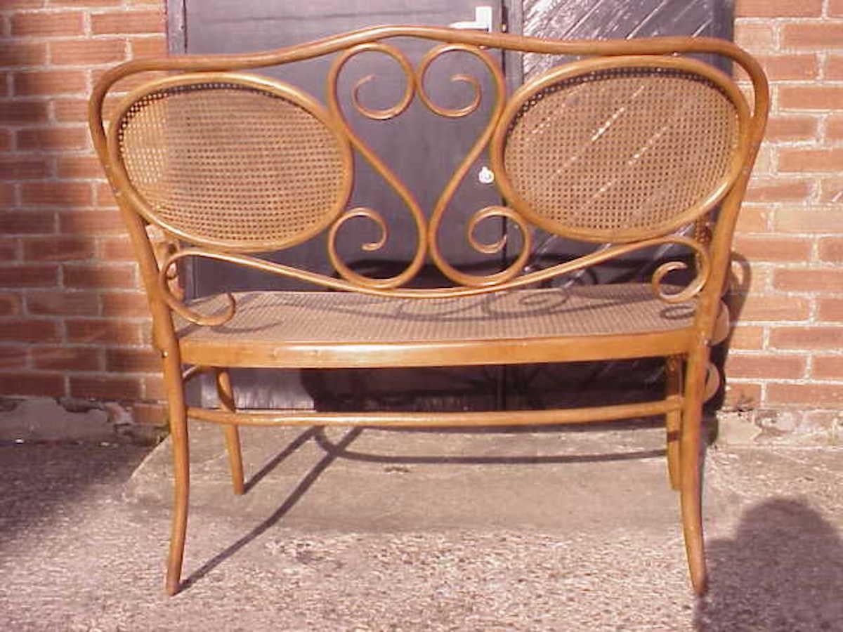 Austrian Thonet, A Bentwood Settee with Scrollwork Decoration with a Caned Seat & Back For Sale