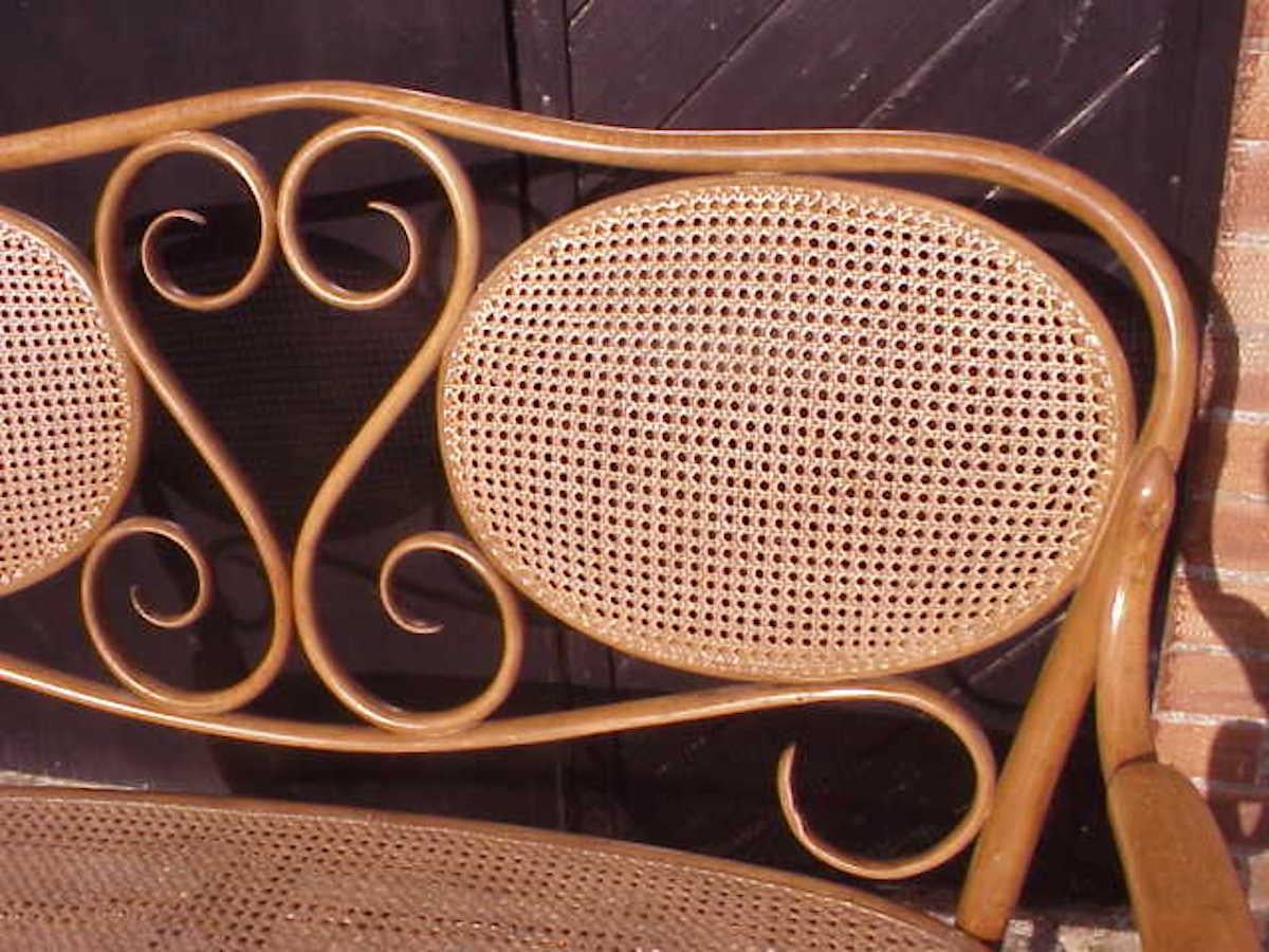 Early 20th Century Thonet, A Bentwood Settee with Scrollwork Decoration with a Caned Seat & Back For Sale