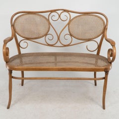 Thonet. Ein Bugholzsofa mit Schnörkeldekoration, Sitz und Rückenlehne mit Rohrgeflecht