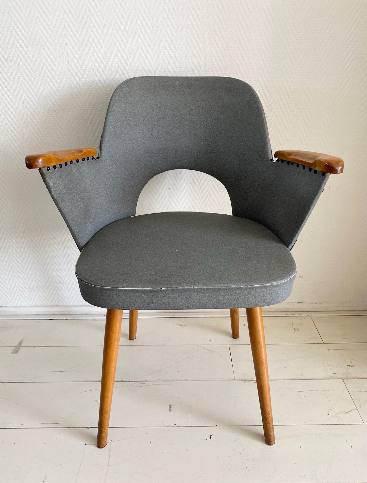 Schöner Thonet Sessel, entworfen von dem Wiener Architekten und Designer Oswald Haerdtl. Der Stuhl hat Armlehnen und Beine aus Holz und ist mit blauem/grauem Kunstleder gepolstert.
Zweimal auf dem Boden gestempelt.

Der Stuhl befindet sich in einem