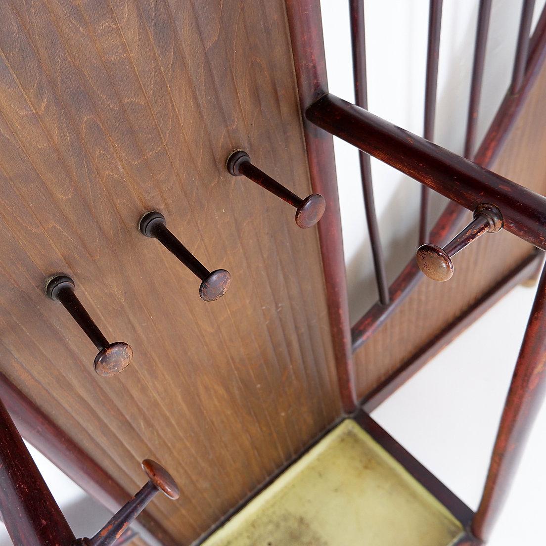 Thonet Jugendstil Wandgarderobe Wien um 1900
Bugholz - Jugendstil - 1900er Jahre
Vorzimmergarderobe Modell N°10806 mit acht Kleiderhaken und einer Klappe, die als Taschenhalter fungiert und einen Schirmhalter sowie einen Spiegel in Kopfhöhe
