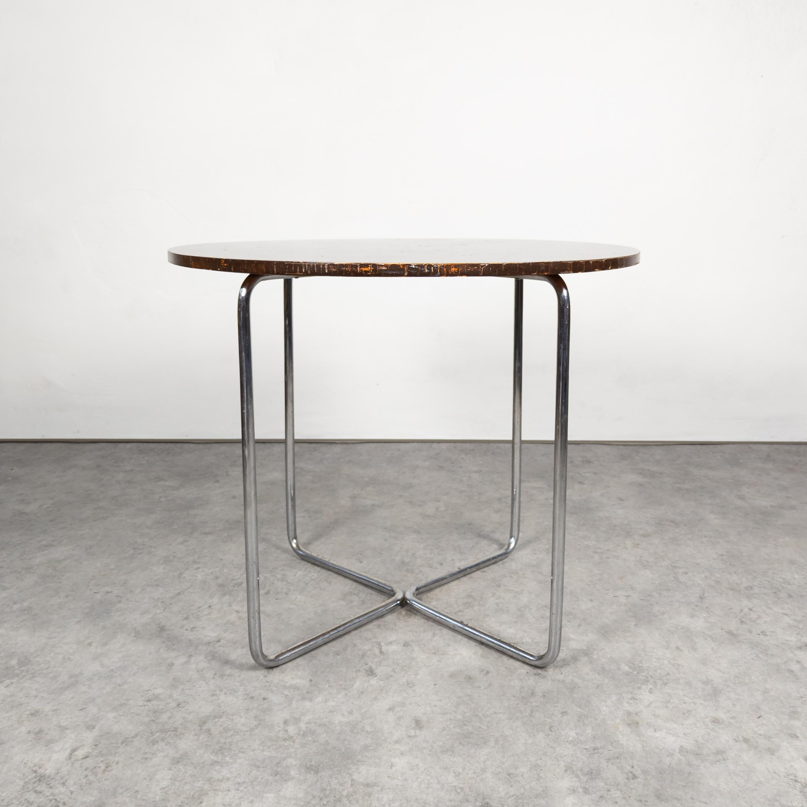 La table Thonet B 27, conçue par Marcel Breuer, est une pièce minimaliste et emblématique. Il se compose d'un élégant cadre en acier tubulaire et d'un plateau circulaire en verre ou en bois, incarnant l'esthétique du Bauhaus, qui veut que la forme