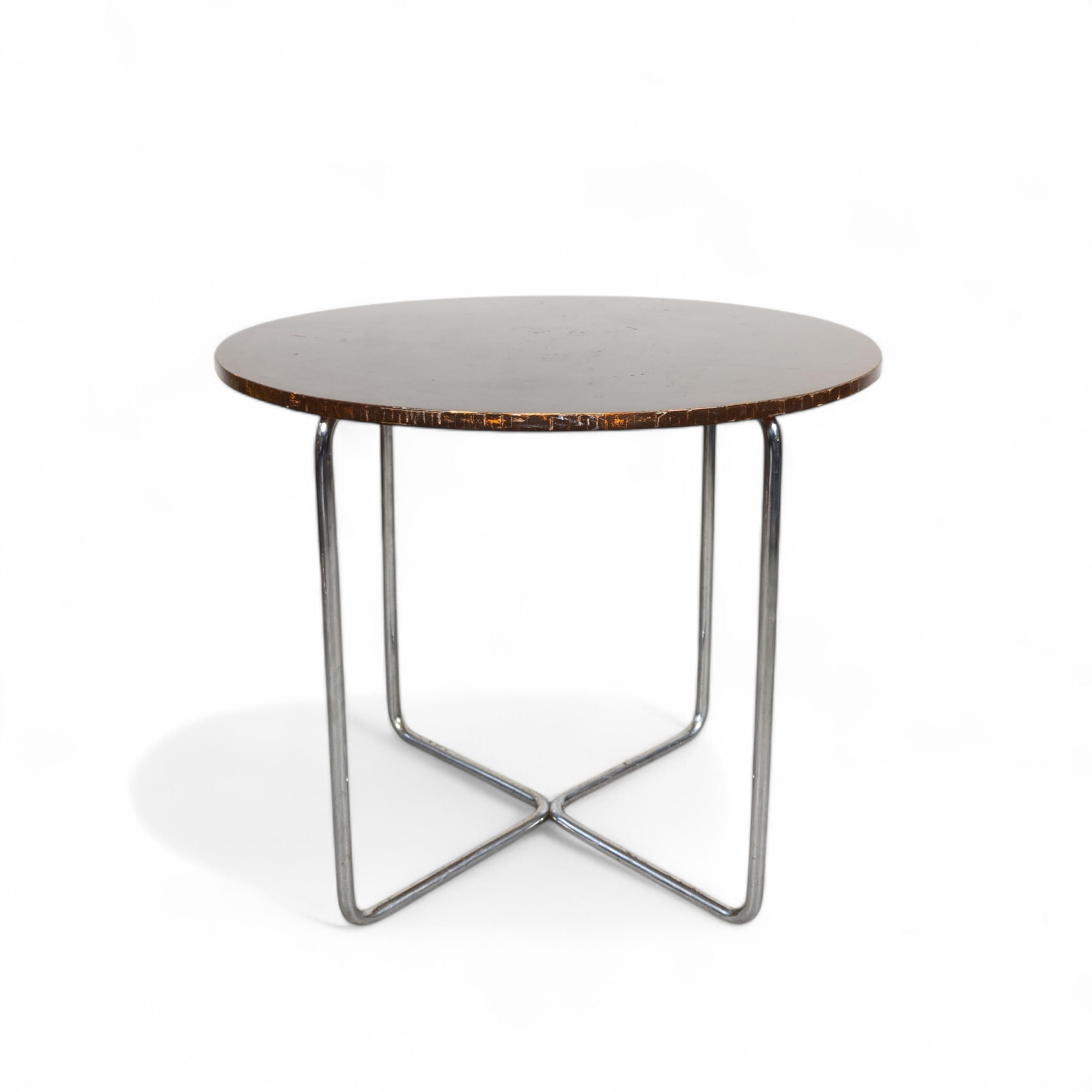La mesa B 27, diseñada por Marcel Breuer, es una pieza minimalista e icónica. Presenta una elegante estructura tubular de acero con un tablero circular de cristal o madera, que encarna la estética Bauhaus de que la forma sigue a la función. Su