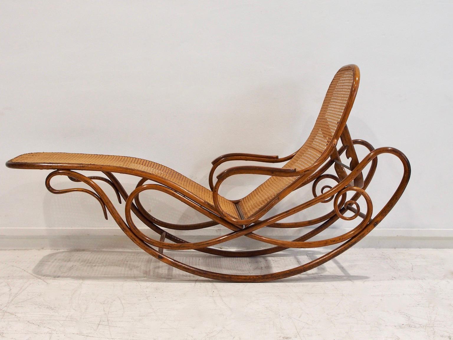 Rara sedia a sdraio a dondolo in legno curvo di Thonet con seduta in canna. Il design della sedia a dondolo modello n. 7500 è attribuito ad August Thonet. 7500 è attribuito ad August Thonet. Inizialmente veniva prodotto senza braccioli, ma a partire