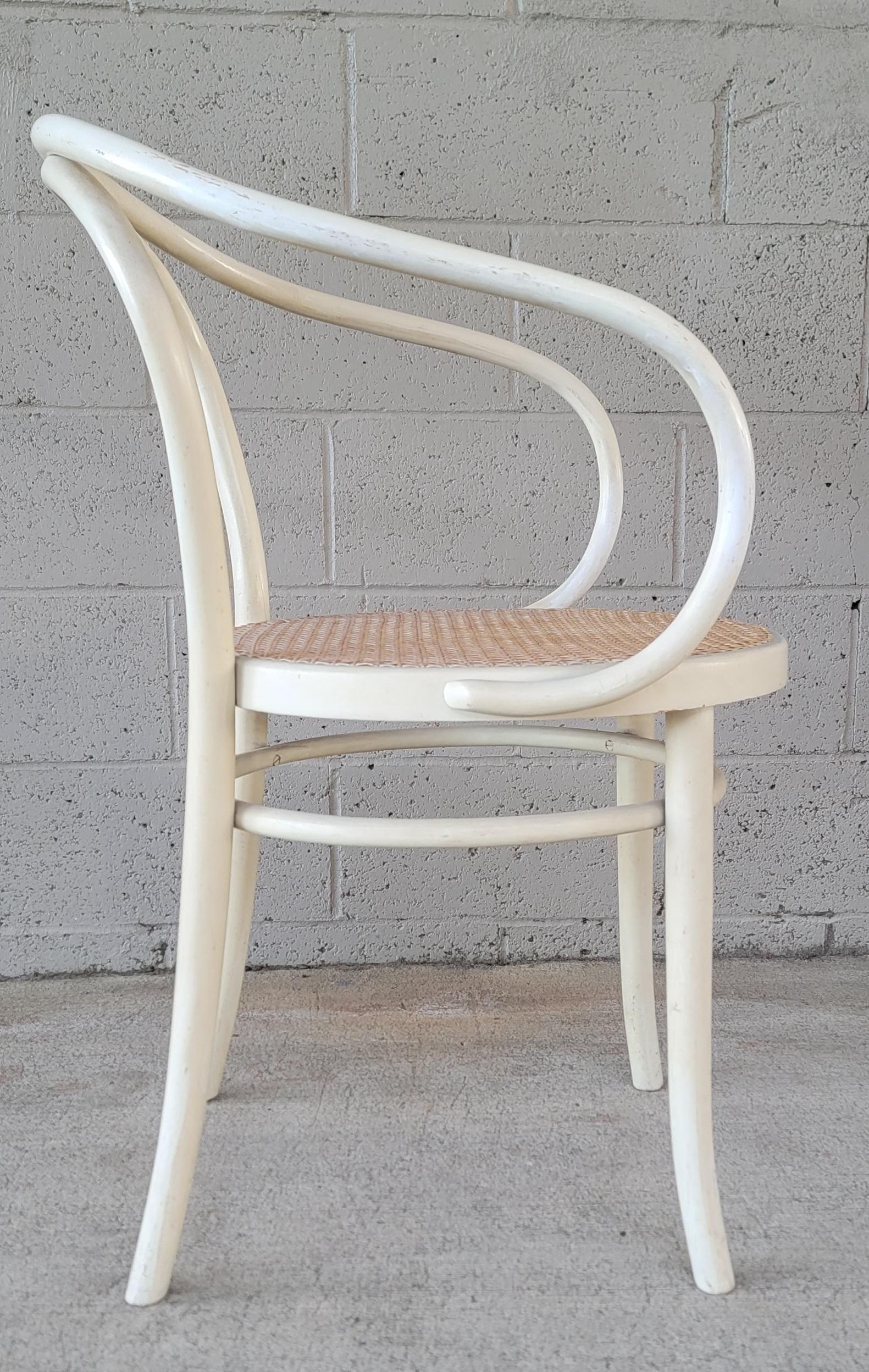 Bentwood armchair with cane seat and painted white finish. Attributed to Wiener Stuhl for Thonet. Graceful, sculptural design. Structurally solid. Light wear to finish from age and use.