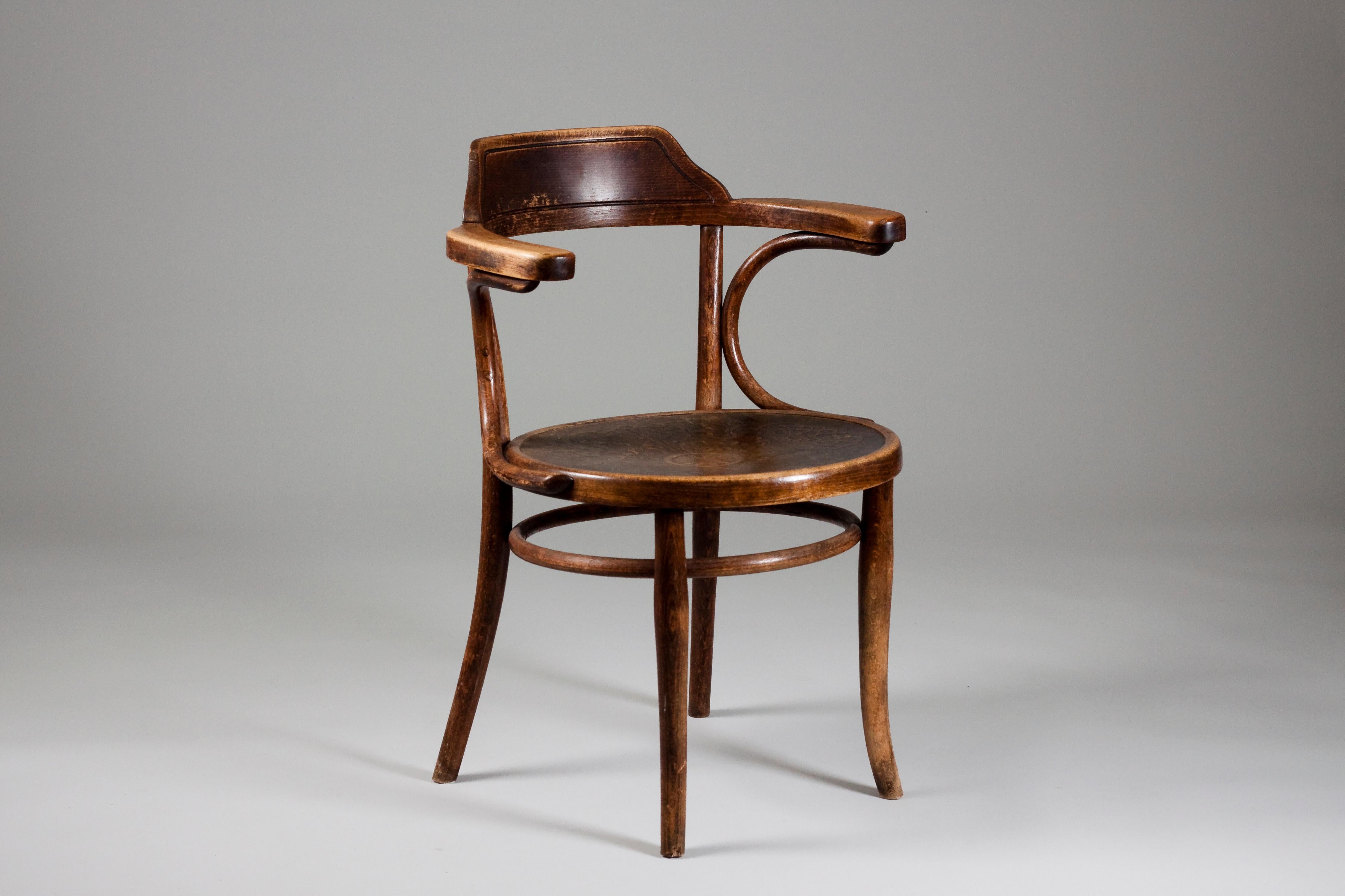Beautifully patinated early 20th century rare Thonet bentwood armchair with a decorative form pressed seat.