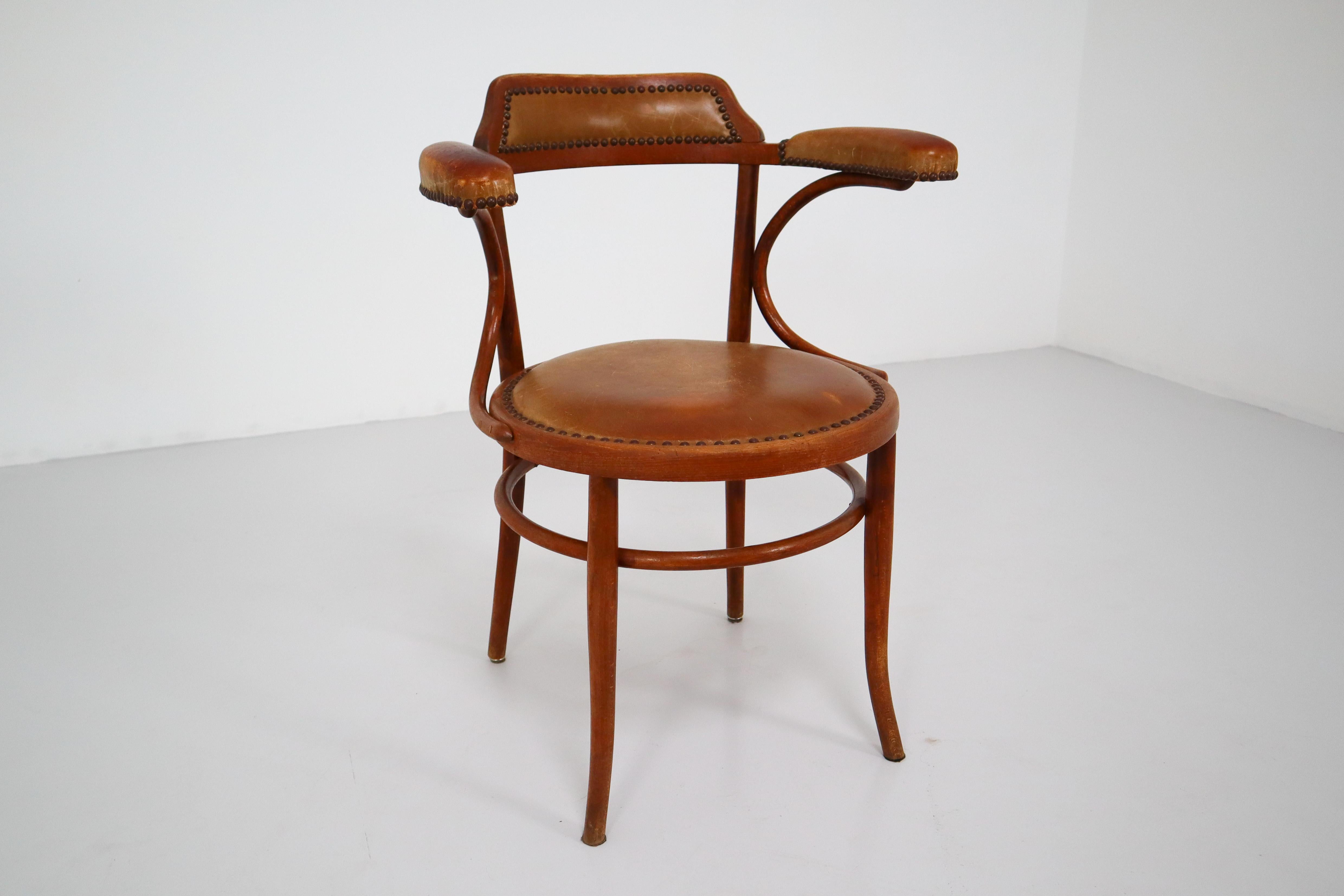 Beautifully patinated early 20th century rare Thonet bentwood armchair with a leather seat and armrest. Fine antique condition with signs of wear.