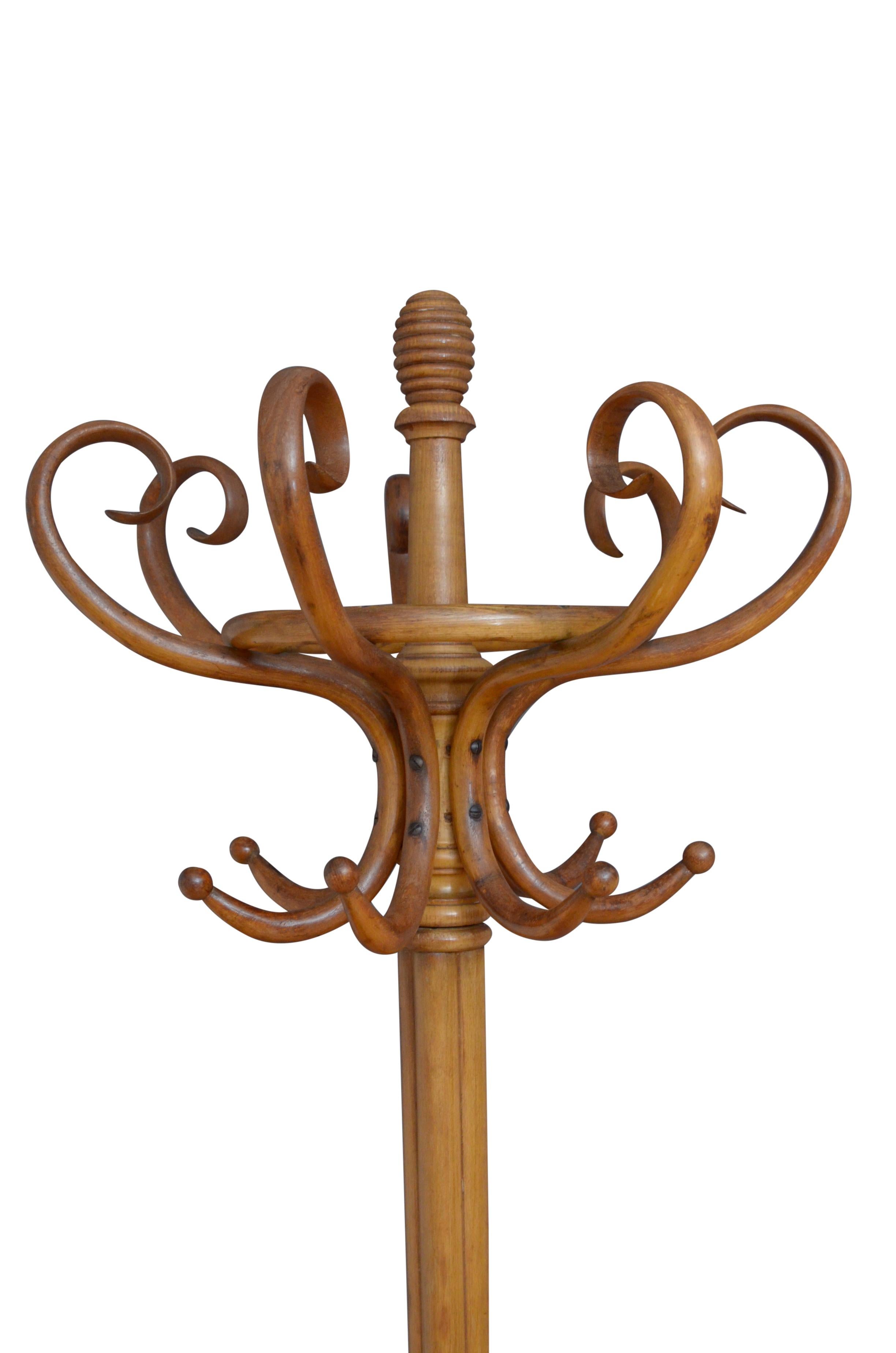 Superb early XXth century bentwood hall stand in light wood, having 8 S shaped coat hooks and 8 bentwood scrolls for hats, surmounted by a turned finial, supported on cluster column terminating in 4 downswept legs with a ring for sticks and