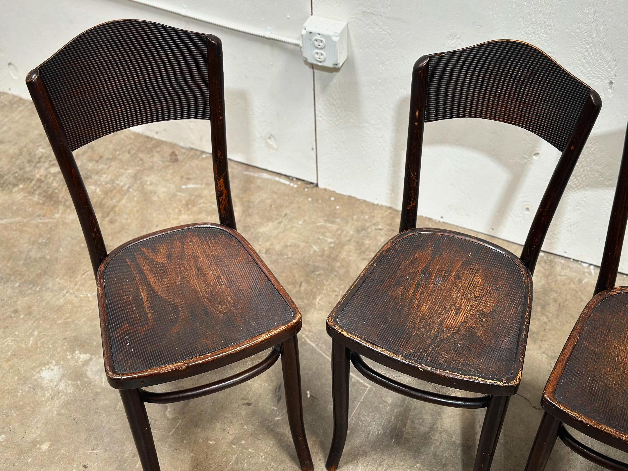 Classic chic set of four Thonet bentwood bistro or cafe chairs, circa 1930s. The chairs are constructed of steamed bent beech wood. These fine chairs are classic examples of the early roots of the modern design movement, circa 1880/ 1920. All four
