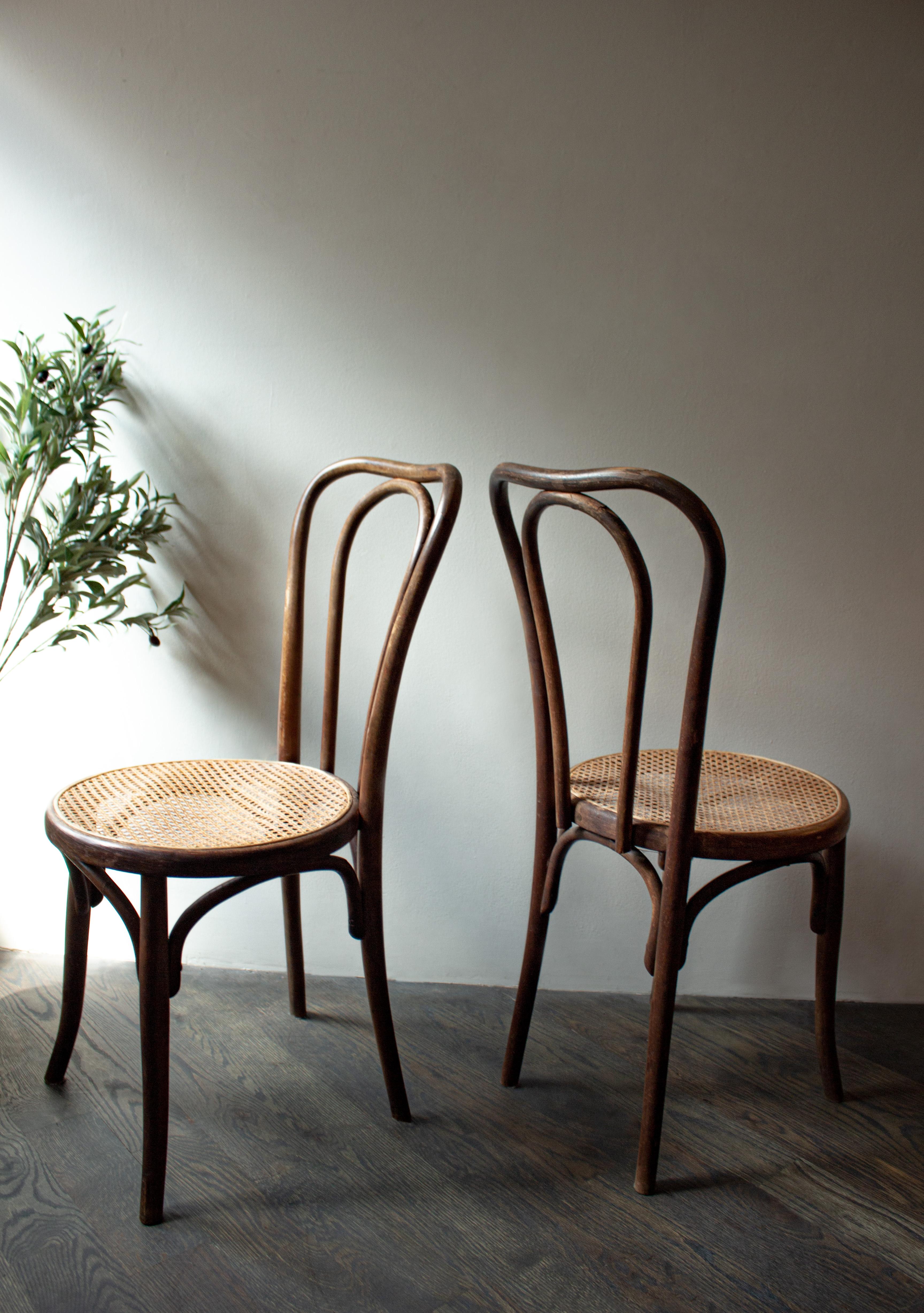Set of timeless, vintage bistro chairs with cane seat and bentwood backing. Perfect for a variety of spaces and styles. 

Cane shows slight wear.