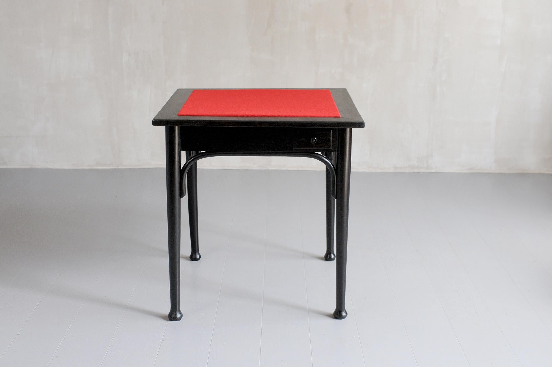 Maison Thonet, Games table in curved and blackened beech, 1940. The square top is dressed in red felt, 4 token-holder drawers are arranged on the sides.
Thonet label under the tray.