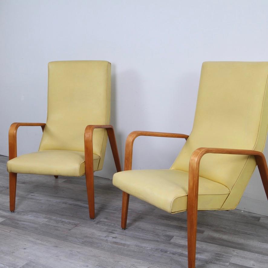 A tribute to how well made these late 50s pieces are, is the fact that the frames and vintage naugahyde have stood the test of time well. Pale yellow naugahyde with bent wood arms. The original seat cushion on one of them could use some batting