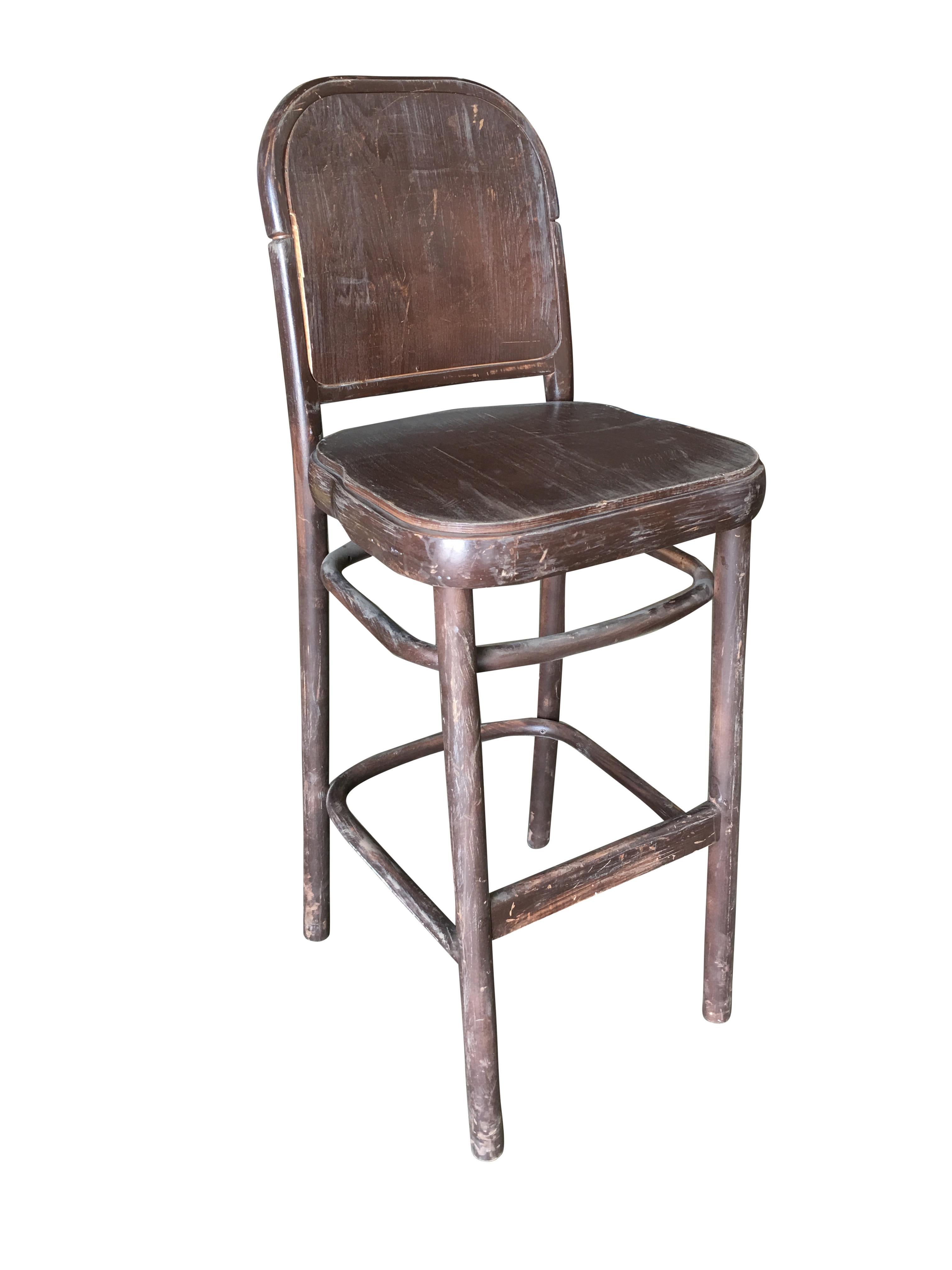 Set of eight bentwood bar stools fashioned after the stylings made famous by Thonet. The bar stools feature a wood seat and backboard along with a footrest.