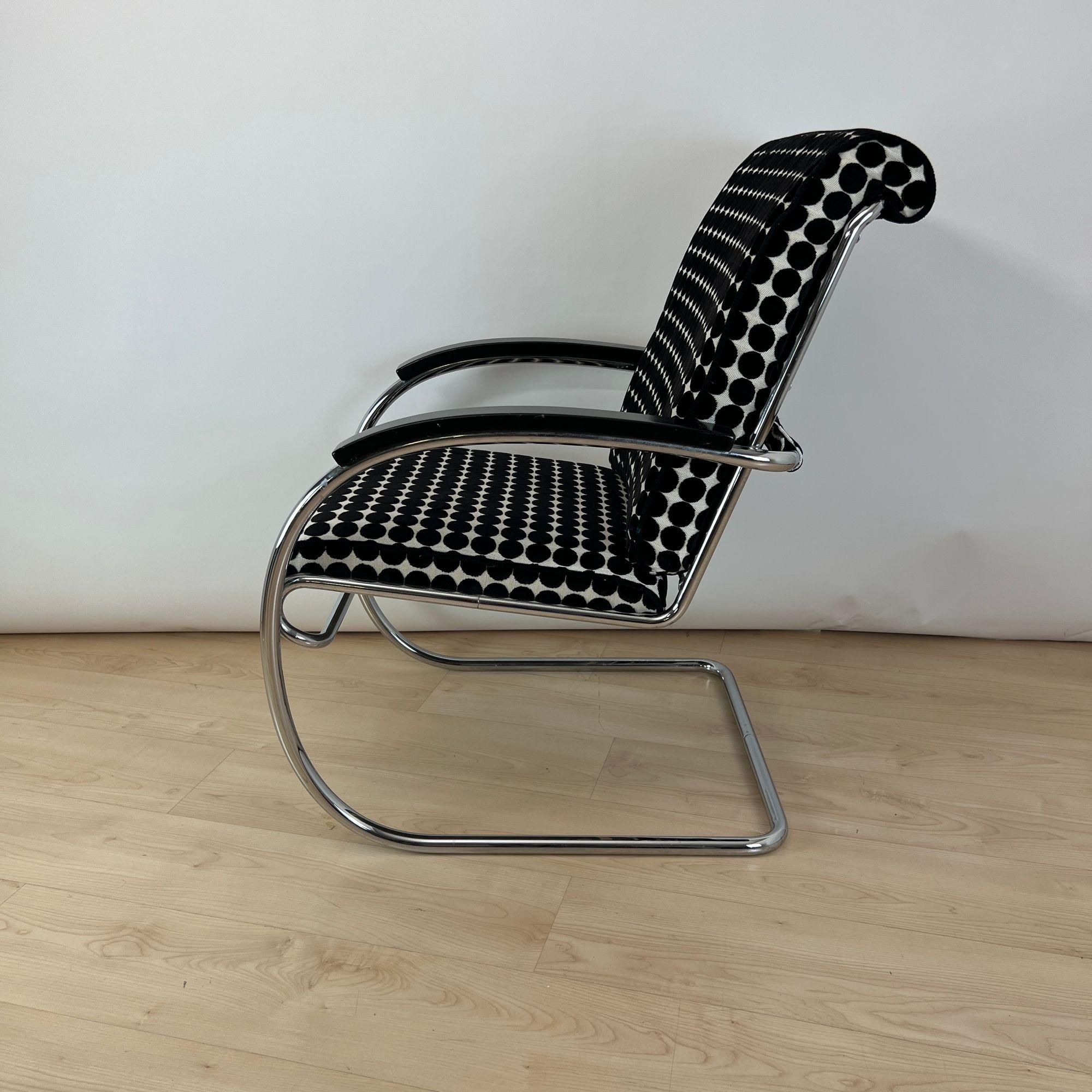 Seltener Bauhaus Stahlrohrsessel 'KS46' von Anton Lorenz für Thonet.
Stahlrohr, verchromt, poliert und zusammengesteckt. Schwarz lackierte Armlehnen aus Holz. Neu gepolstert mit schwarz-weiß gepunktetem Samtstoff von JAB.
Modell: KS 46