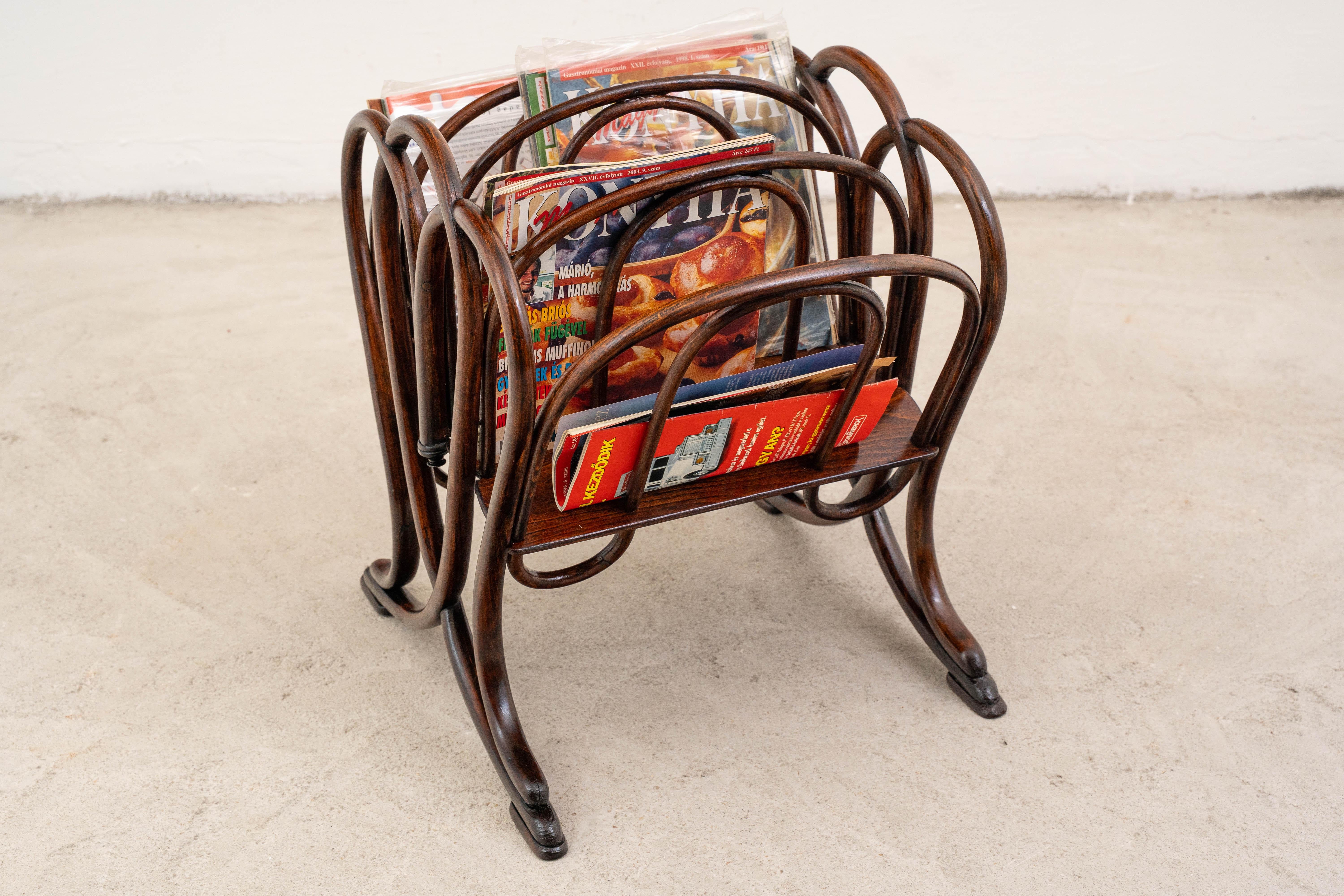Il portariviste Thonet n. 1, documentato nel catalogo Thonet del 1904 (pag. 87), è un elegante e precoce esempio di artigianato in legno curvato. Prodotto dalla rinomata fabbrica Thonet in Austria, questo pezzo esemplifica l'approccio innovativo al