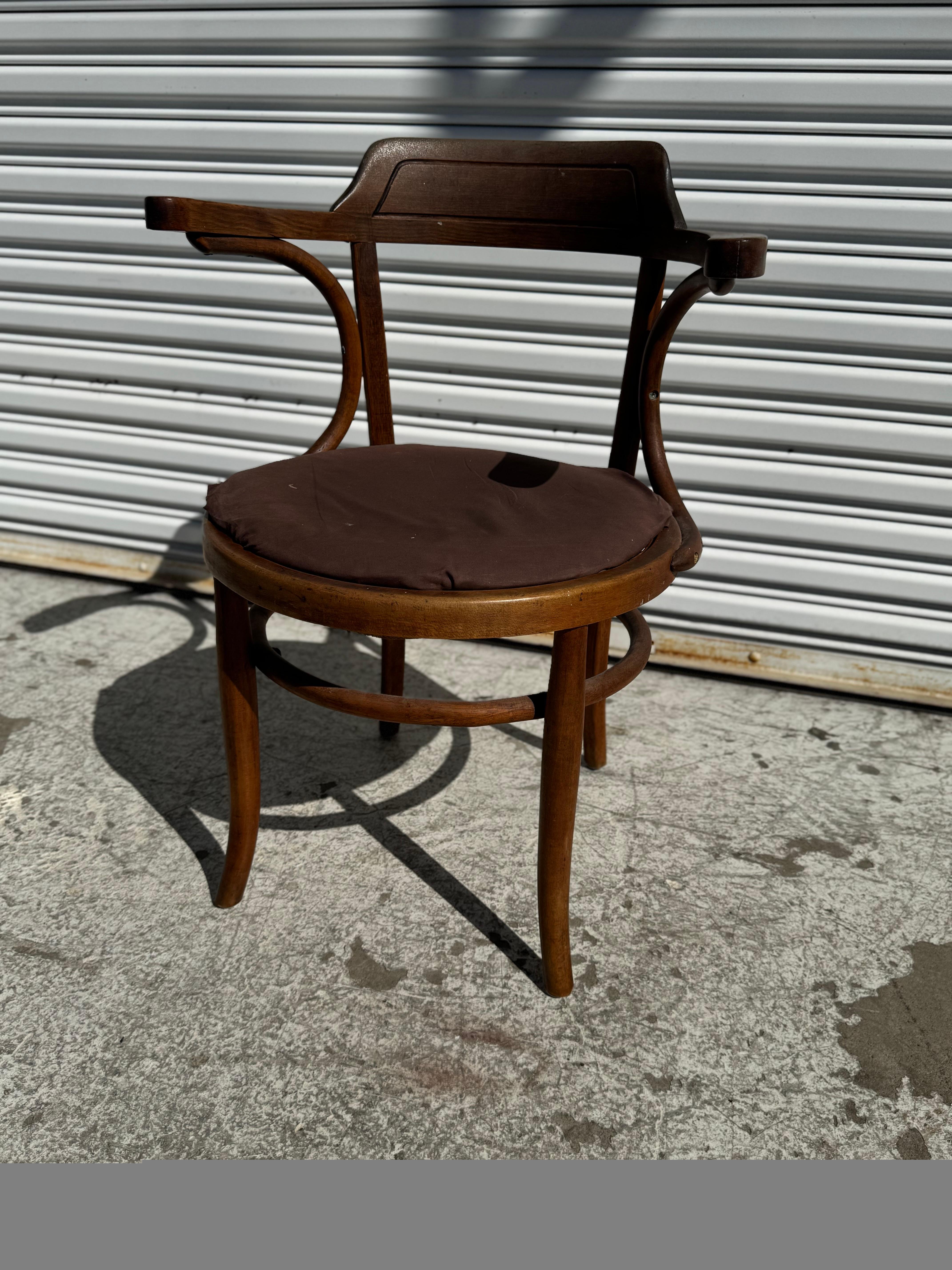 Questa poltrona è realizzata in stile Thonet-Mundus.
I braccioli sono in legno di betulla e stabilizzano lo schienale della sedia.
Le gambe sono stabilizzate da barelle in legno curvato.
La sedia è realizzata in un ricco legno di faggio colorato.