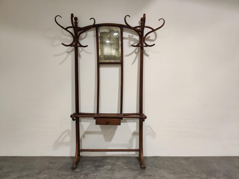 Early 20th century coat stand by Thonet, Vienna.

The coat stand features very elegantly shaped steam bended wooden hooks with a gorgeous worn mirror and integrated console with central drawer.

Great decorative piece for a hallway.

Good