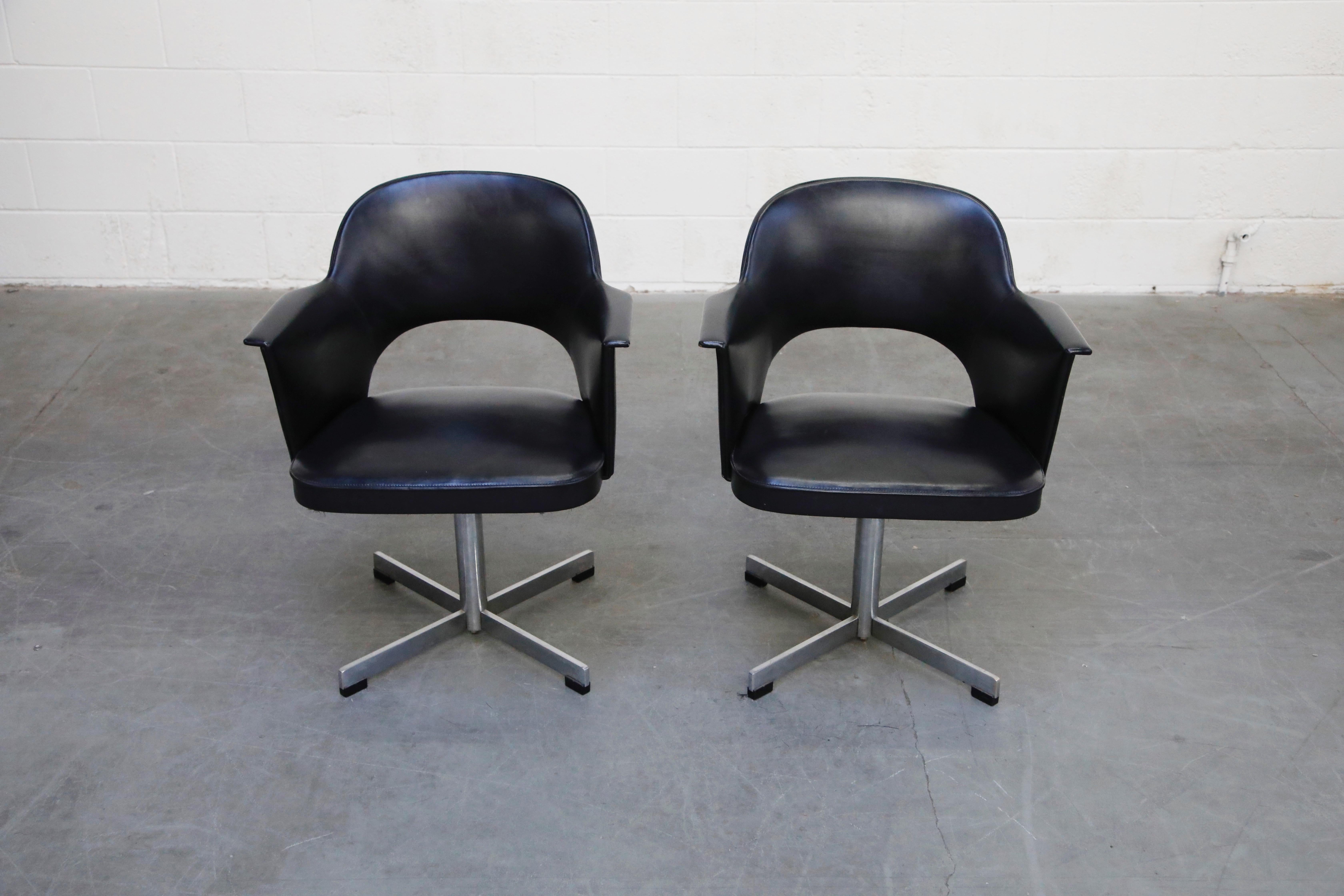This stylish pair of swivel armchairs are by Thonet, circa 1960s. Featuring Thonet labels underneath the seat, Eero Saarinen styled open back, Fabricius & Kastholm styled tulip arms, sleek four prong swivel base, and a beautiful silhouette in its