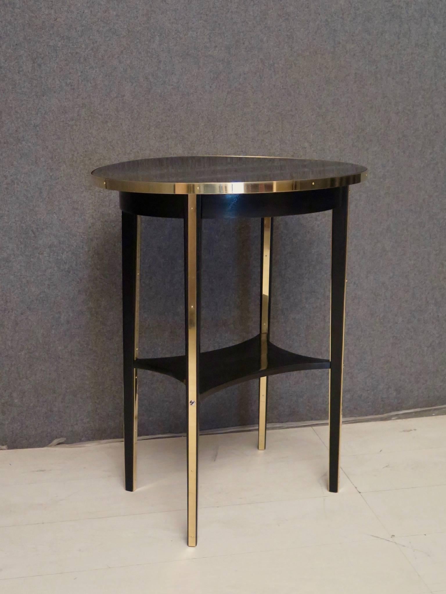 Clean and linear Thonet side table, original Austrian Art Nouveau.Embellished with a fantastic polished brass finish.

All in beechwood, polished in black shellac with brass inserts. Formed by an oval top, bordered by a brass flat, held by brass