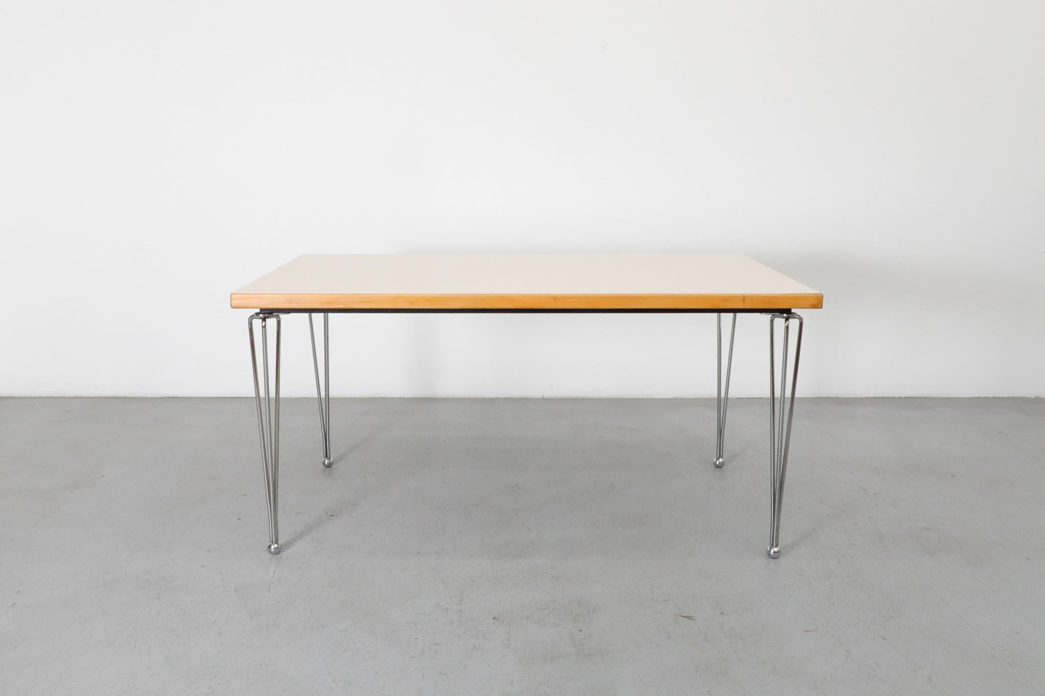 Postmodern dining table designed by Marius van den Wildenberg for Thonet in the 1980s. This striking piece features a distinctive mix of materials, including tapered chrome legs, a wood and black metal frame, and a subtly textured eggshell laminate