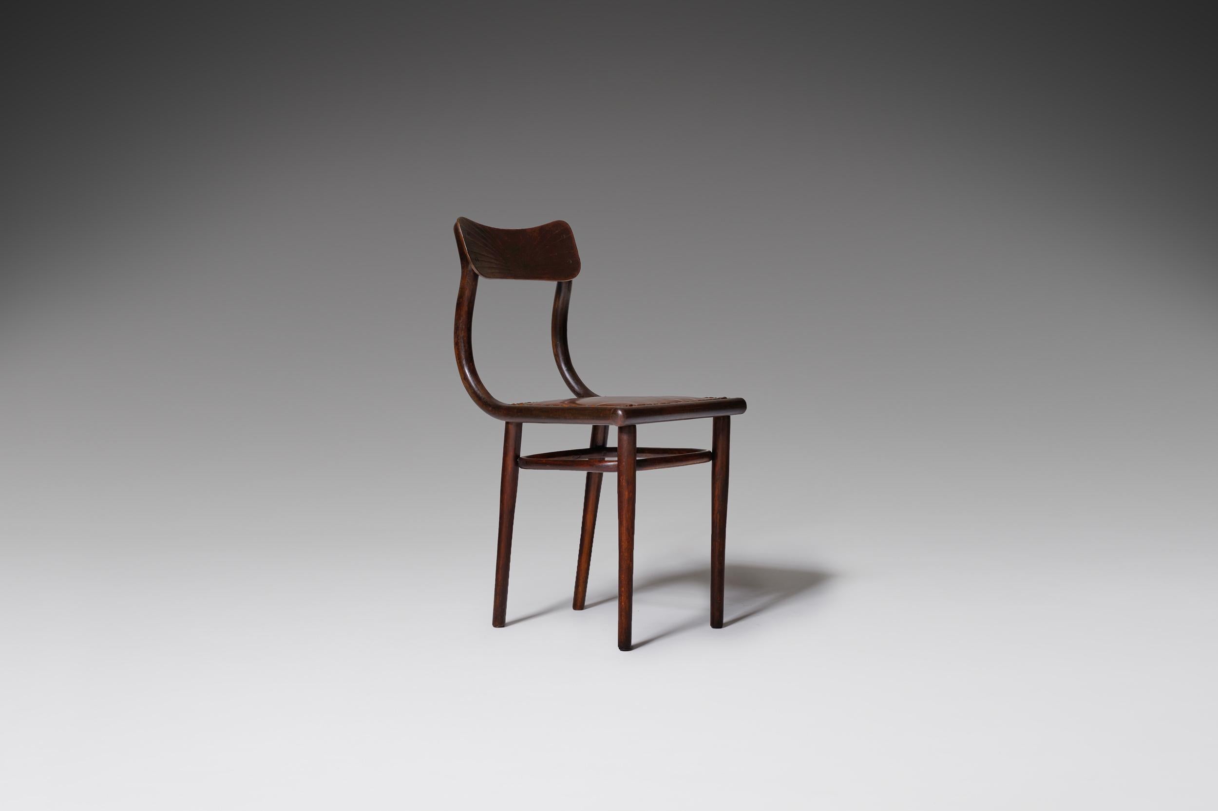 Sculptural Thonet side chair, early model from the beginning of the 1900s. The chair has a beautiful bent wooden frame with a nicely patinated cognac leather seat which is finish with authentic brass nails. The bended wooden frame holds an elegant