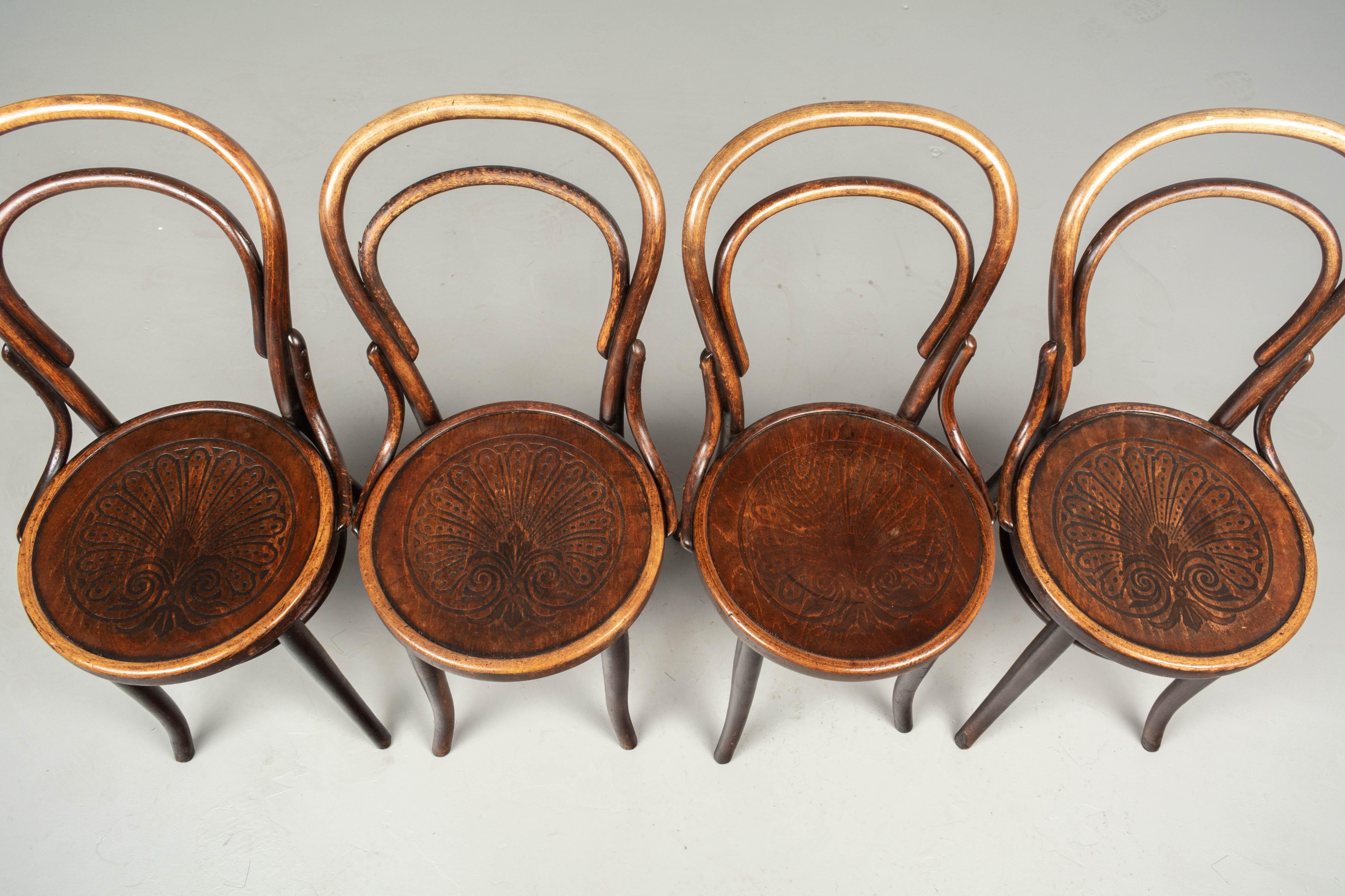 A set of four Art Nouveau bentwood bistro chairs with embossed palmette decoration. The chairs have 14.5