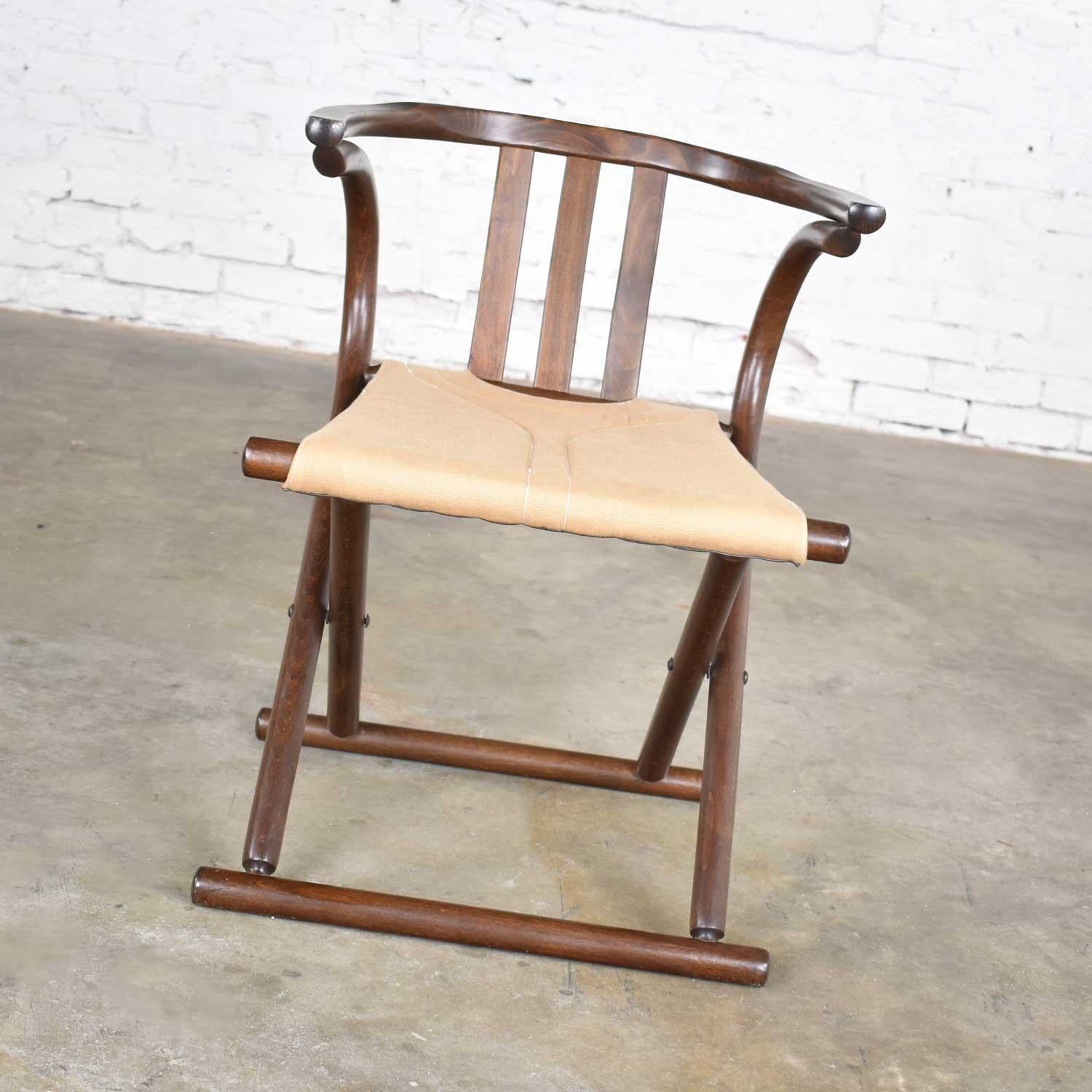 Handsome Bauhaus Campaign style walnut tone beach bentwood folding chair with a canvas sling seat made in Romania in the style of Thonet. It is in wonderful vintage condition. We did nothing but clean it and did not find any outstanding flaws only