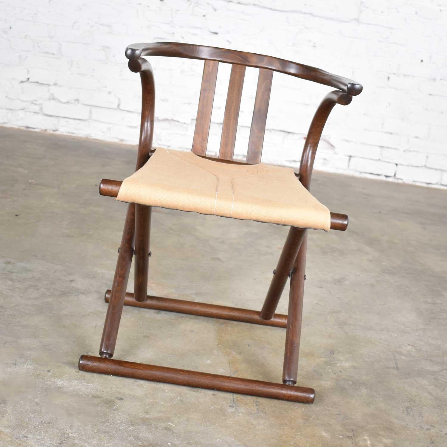 Handsome Bauhaus Campaign style walnut tone beach bentwood folding chair with a canvas sling seat made in Romania in the style of Thonet. It is in wonderful vintage condition. We did nothing but clean it and did not find any outstanding flaws only