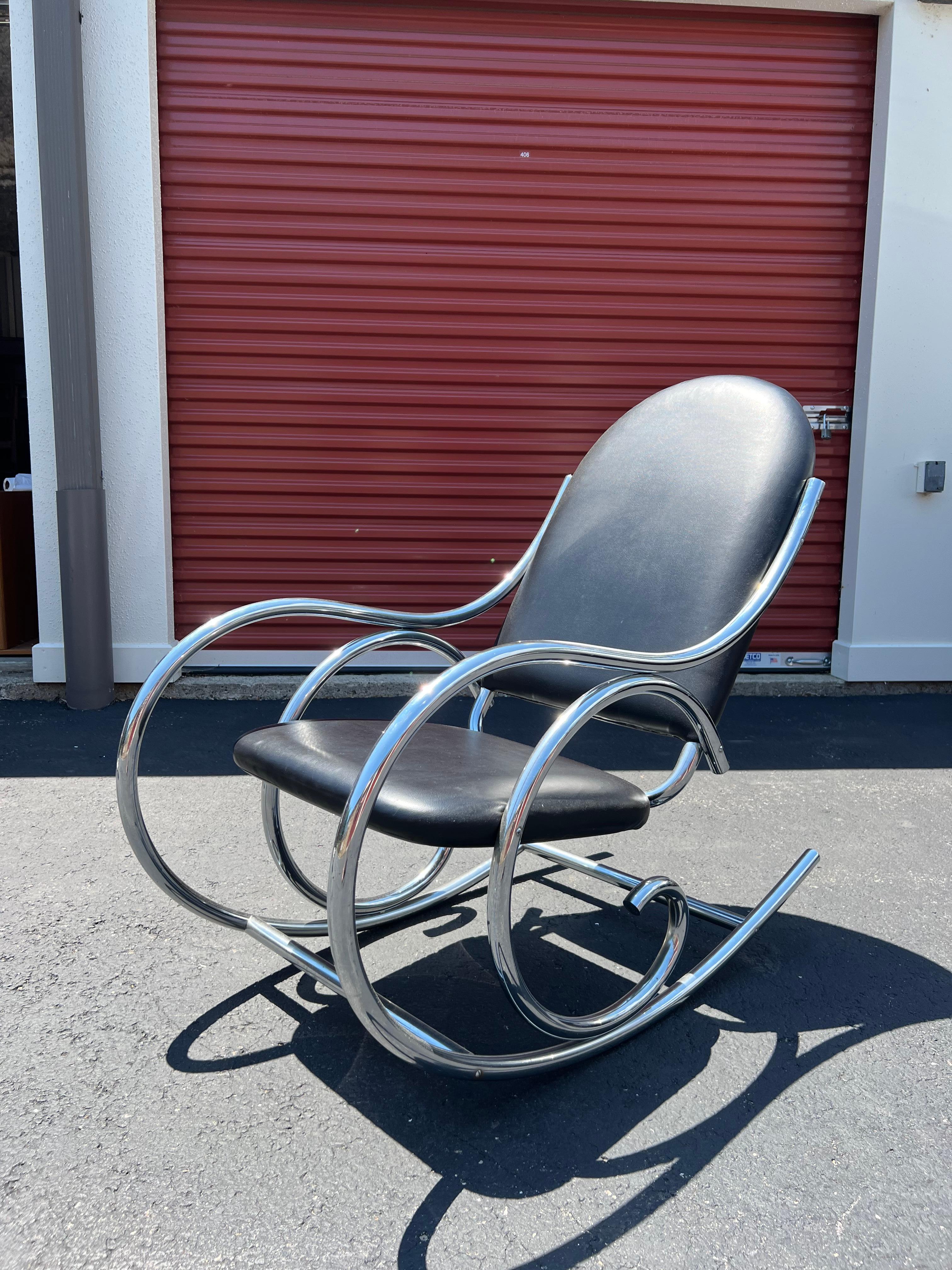Mid-Century Modern rocking chair with curved chrome and original black Naugahyde. The chrome base and upholstery are in good condition overall - only light scuffing and scratching.