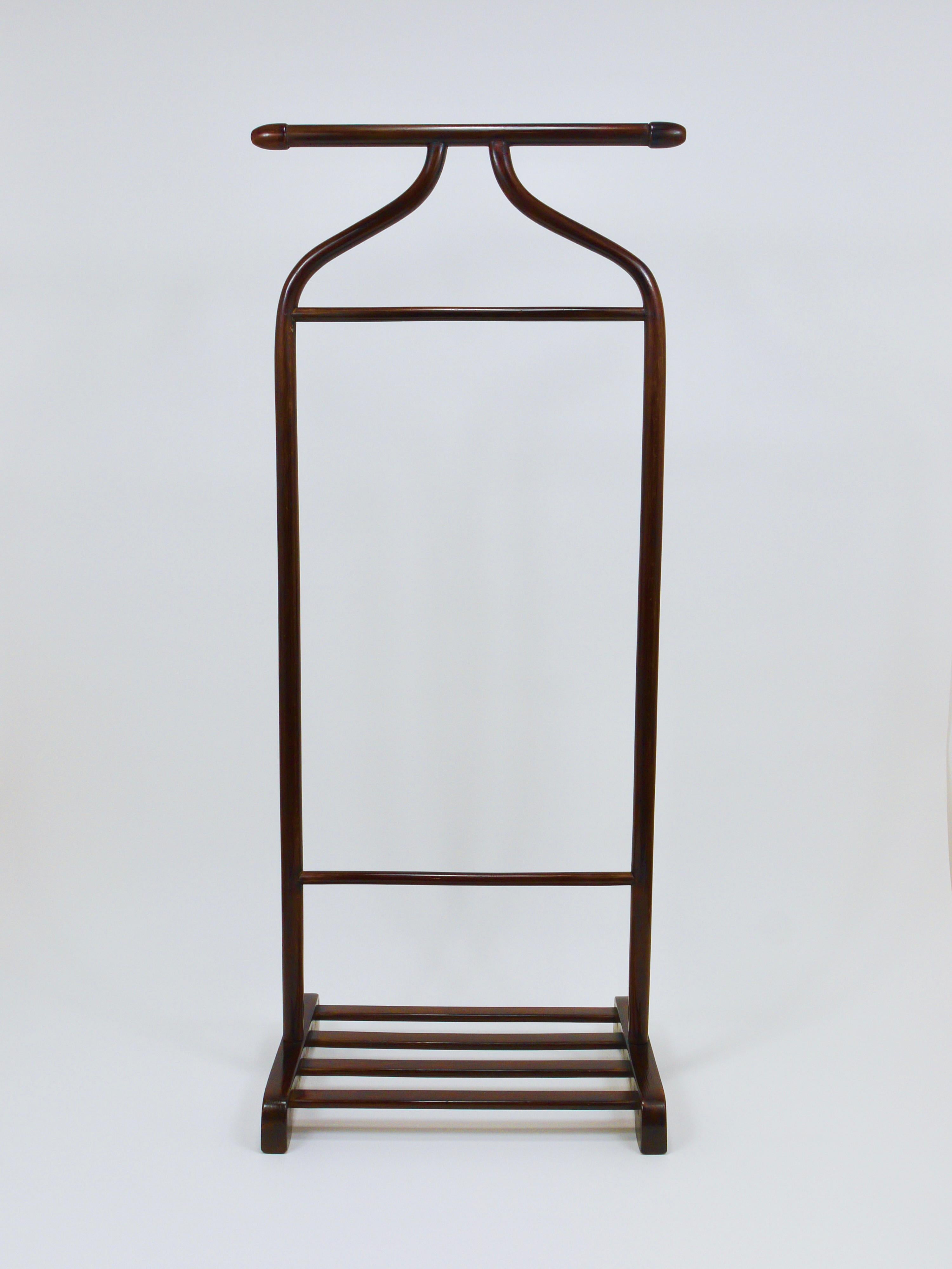 An elegant Art Deco gentleman’s valet or dressing stand from the 1920s, designed and crafted by Gebrüder Thonet Vienna in Austria. This piece is made of bentwood beech in a beautiful dark brown color. Featuring a coat hanger and a pant bar, it is