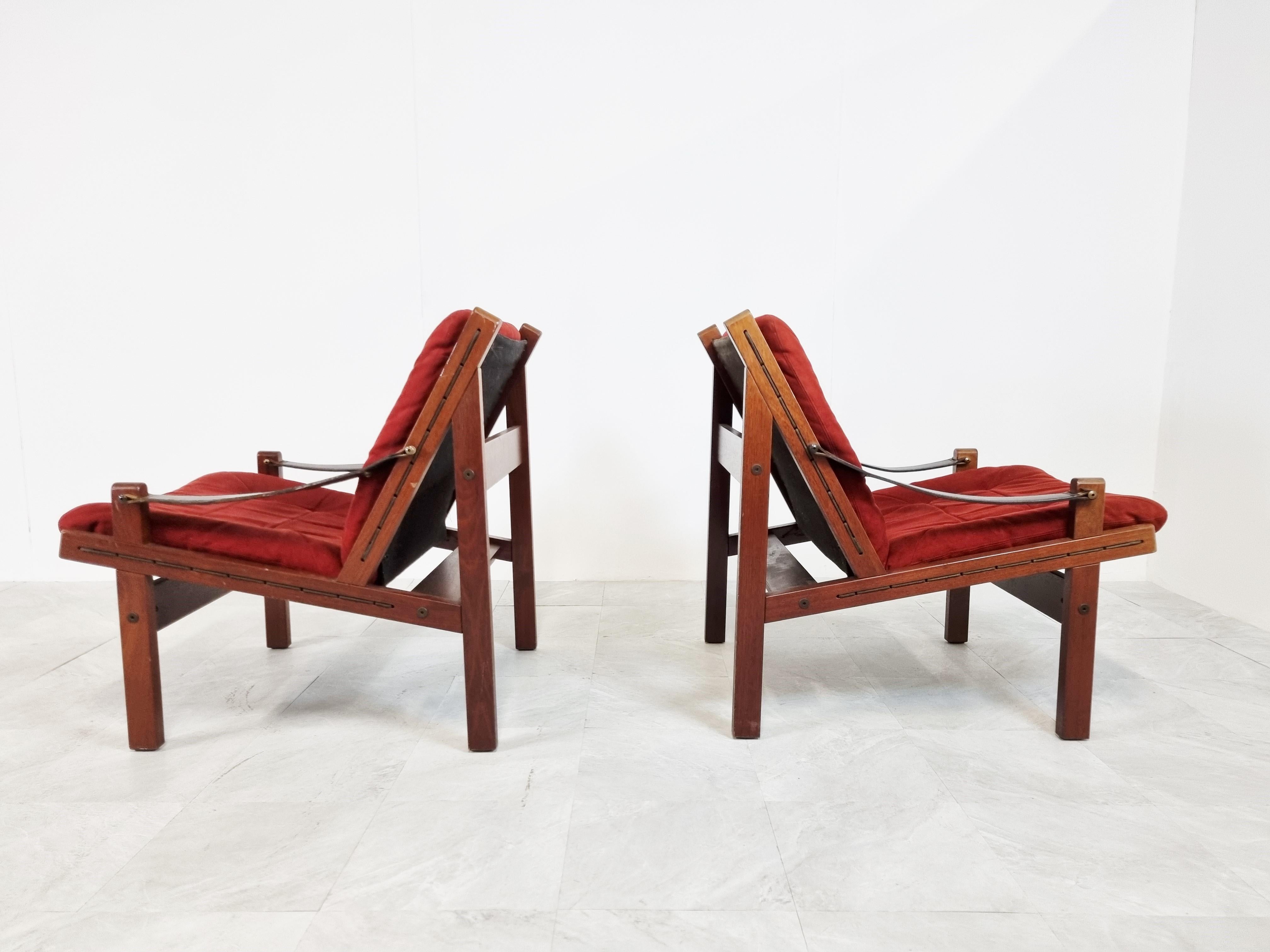 Charming pair of Norwegian armchairs designed by Torbjorn afdal for Bruksbo Norway.

Called 'Hunter chairs' but also referred to as Safari chairs.

Red velours upholstery, wooden frames and sling leather armrests

The chairs are in overal good