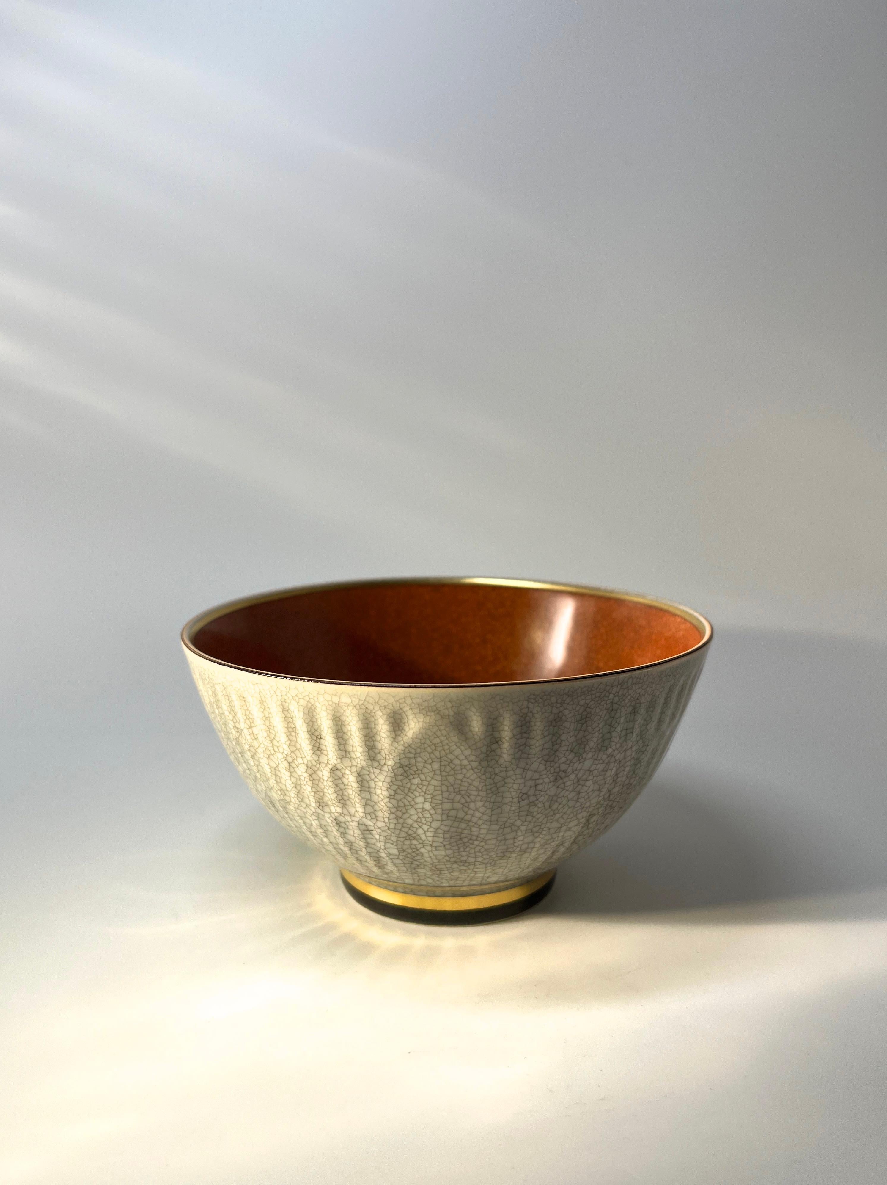 Decorative Royal Copenhagen porcelain bowl designed by Thorkild Olsen
Grey crackle glaze in relief to exterior, featuring a broad gilded band around plinth. 
Rich terratcotta crackle glaze interior
Circa 1955
Stamped and numbered 3431
Height 2.75