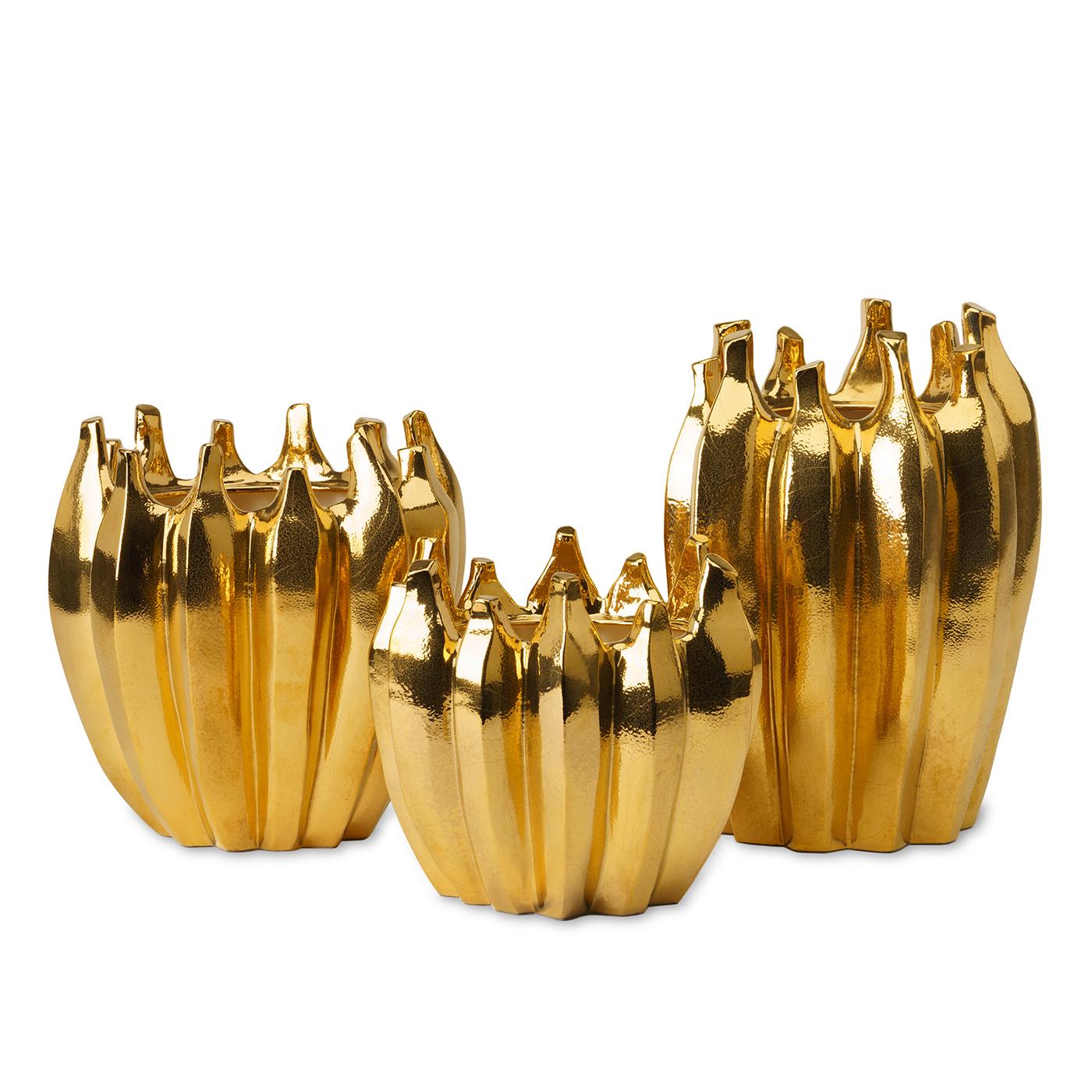 Brimming with opulent character, this luminous vase is distinguished by an extraordinary polished gold finish that enhances its grooved, rounded silhouette with spiked rims. A superb accent piece for an elegant entryway or living room decor, this