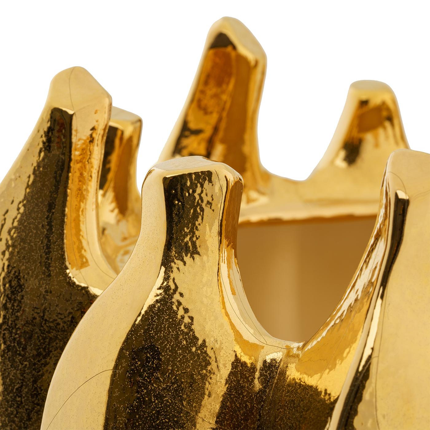 This splendid vase will add a luminous character to a refined entryway or living room decor, thanks to sublime craftsmanship and singular design. Handmade of ceramic, its grooved, rounded silhouette is finished in a polished gold hue that enhances
