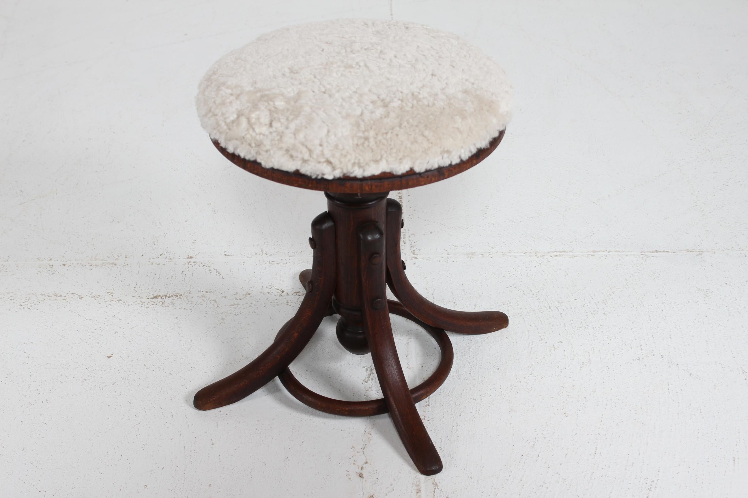 Taburete de piano alemán Thornet regulable en altura, de haya teñida oscura, con asiento redondo tapizado con piel de oveja nueva. Fabricado hacia el año 1900.
Es posible ajustar la altura del taburete dándole la vuelta.

Diámetro 40 cm
Altura 58/42