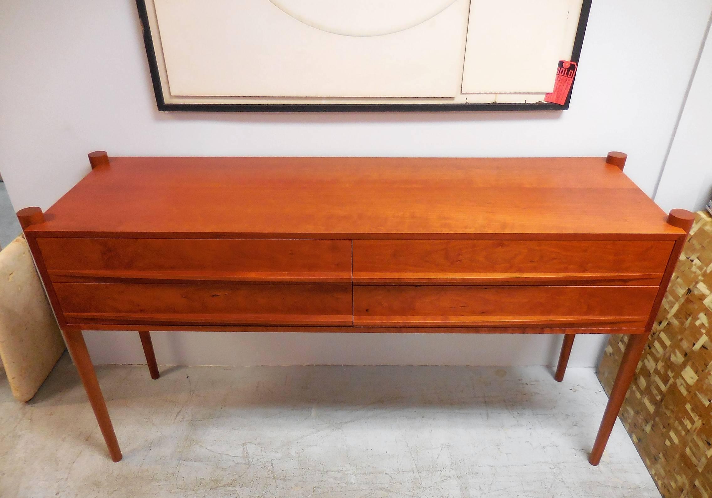 Great looking cabinet by Thos Moser. Hardwood construction in cherry with the secondary wood being oak, used to created the 4 dovetailed drawer interiors. Note the elliptical pulls and the slender tapering legs. The cabinet is a little taller than