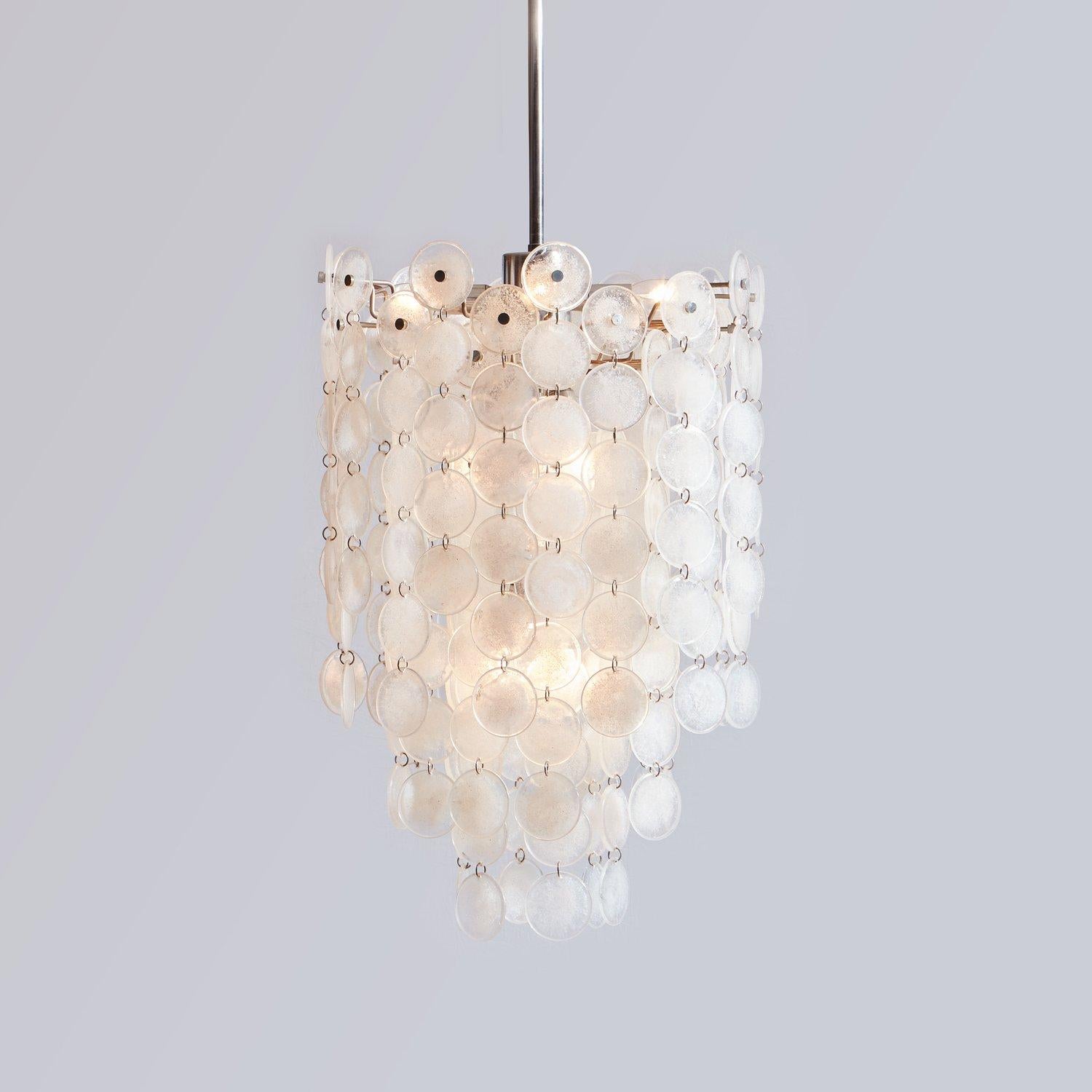 A “Thousand Moons” chandelier designed by Carlo Nason for Mazzega in the 1960s. This chandelier features 178 clear and white hand blown Murano glass discs held together with small chrome rings. It has a chrome frame, rod and canopy with ornamental