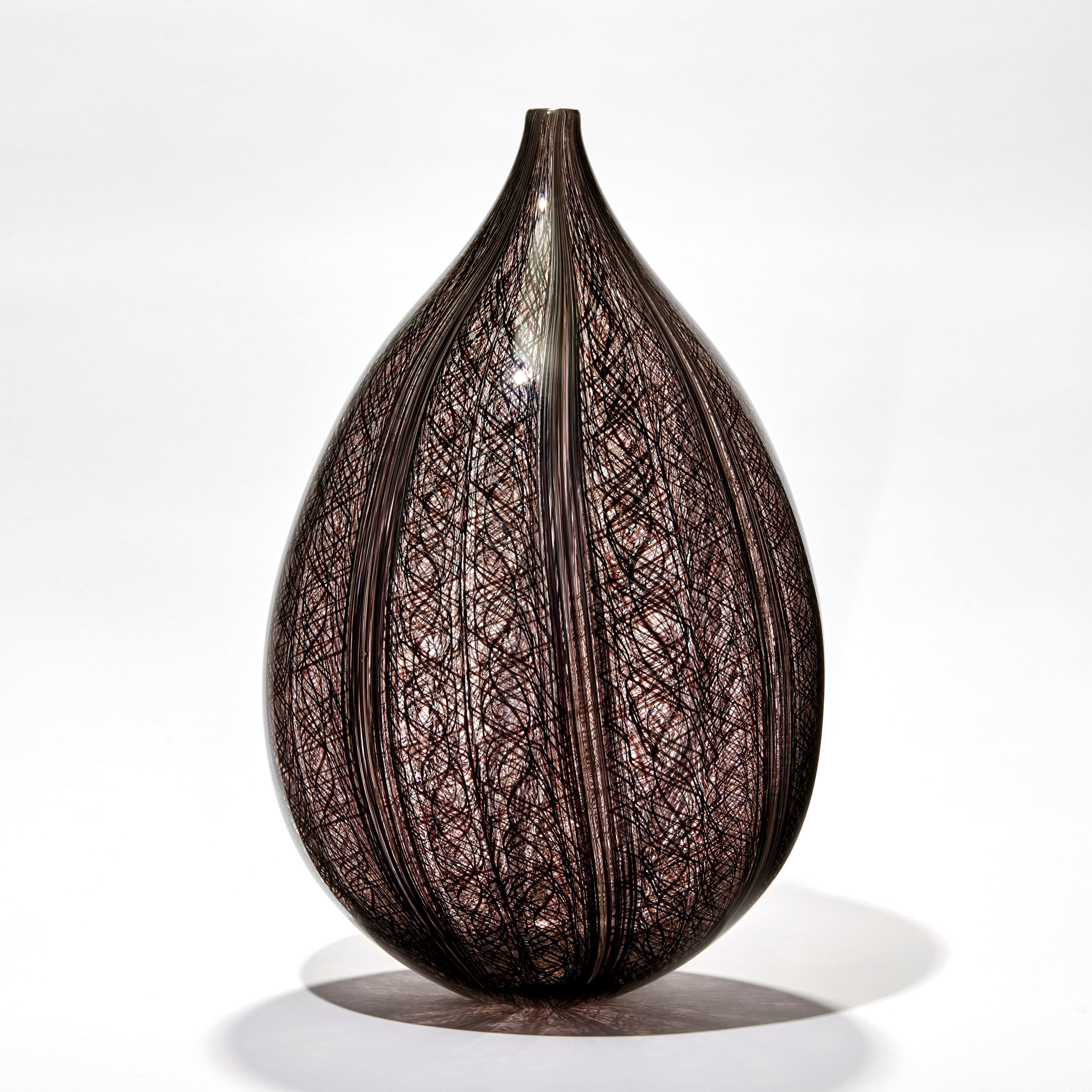 Threads IV is a unique handblown clear and aubergine/dark brown glass sculpture by the Swedish artist Ann Wåhlström. Created to form an elegant teardrop shape, finishing in a refined thin neck, very fine canes of dark brown/aubergine glass appear