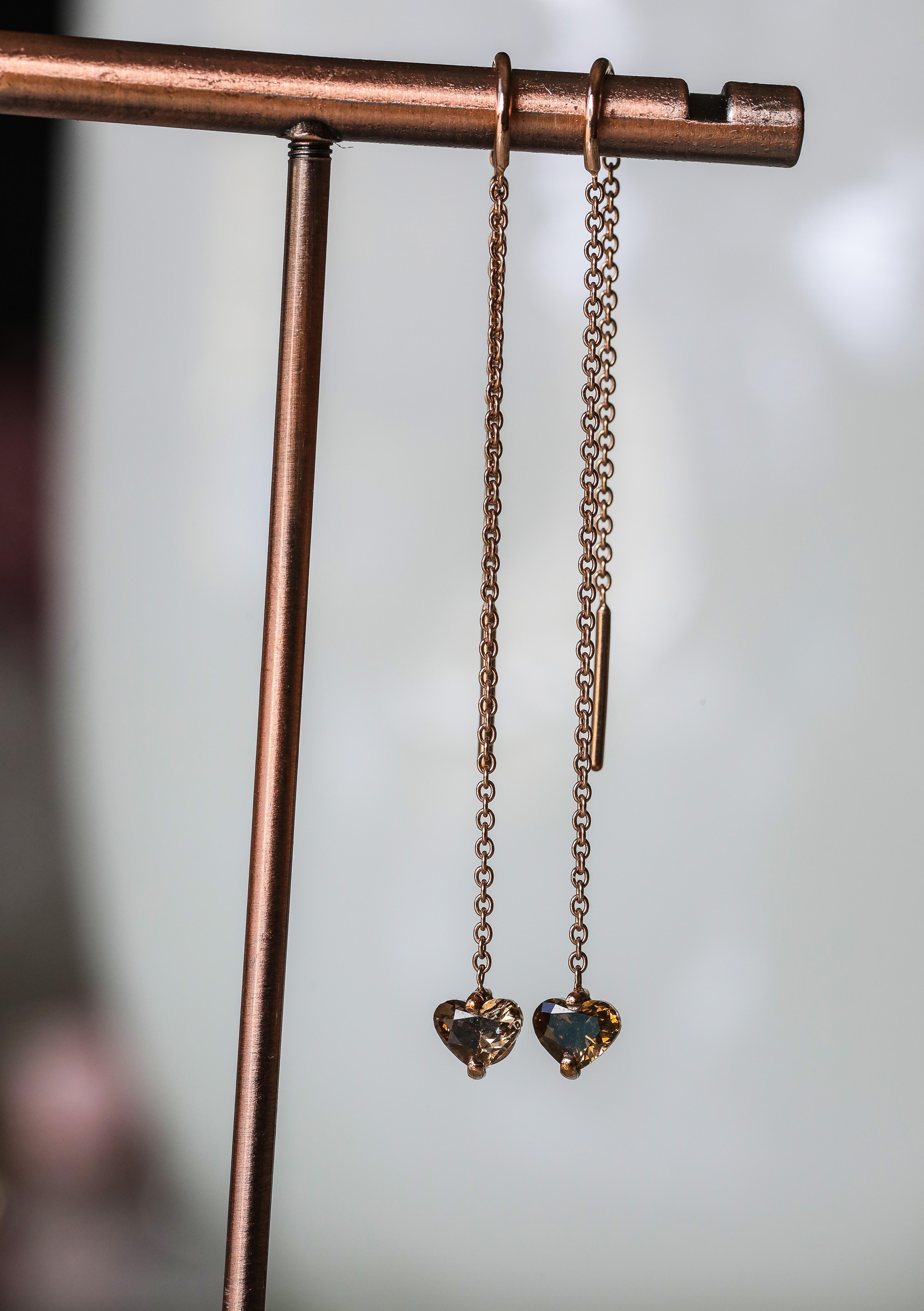 Hand made in 9 karat Rose gold delicately hanging from a chain are .25 cts of Champagne coloured Diamond hearts on each earring. These light weight floating diamond hearts are easily worn on any occasion. Champagne diamonds have risen in popularity