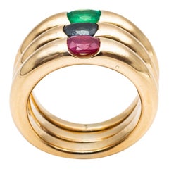 Three 18 Karat Gold Bangles Rings Set with an Emerald, a Sapphire, and a Ruby