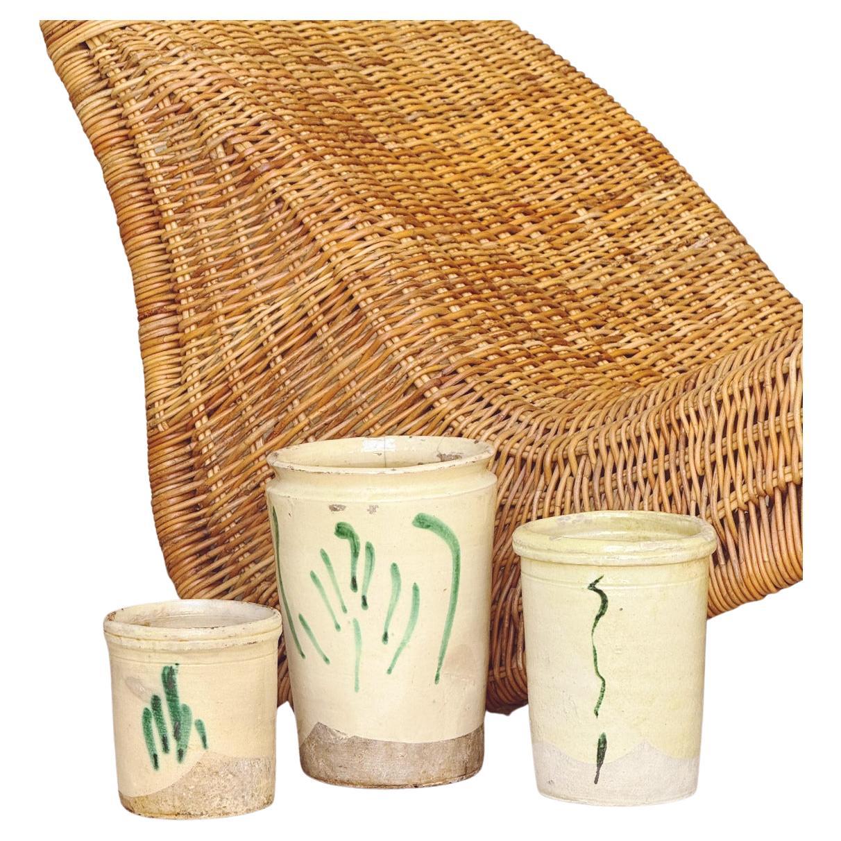 Trois pots rustiques avec des décorations en forme d'arbre de vie sur le devant. Ces pots ont été fabriqués au début des années 1900 et servaient à stocker les céréales et les légumineuses. L'arbre de vie symbolise la bonne fortune et la longévité.