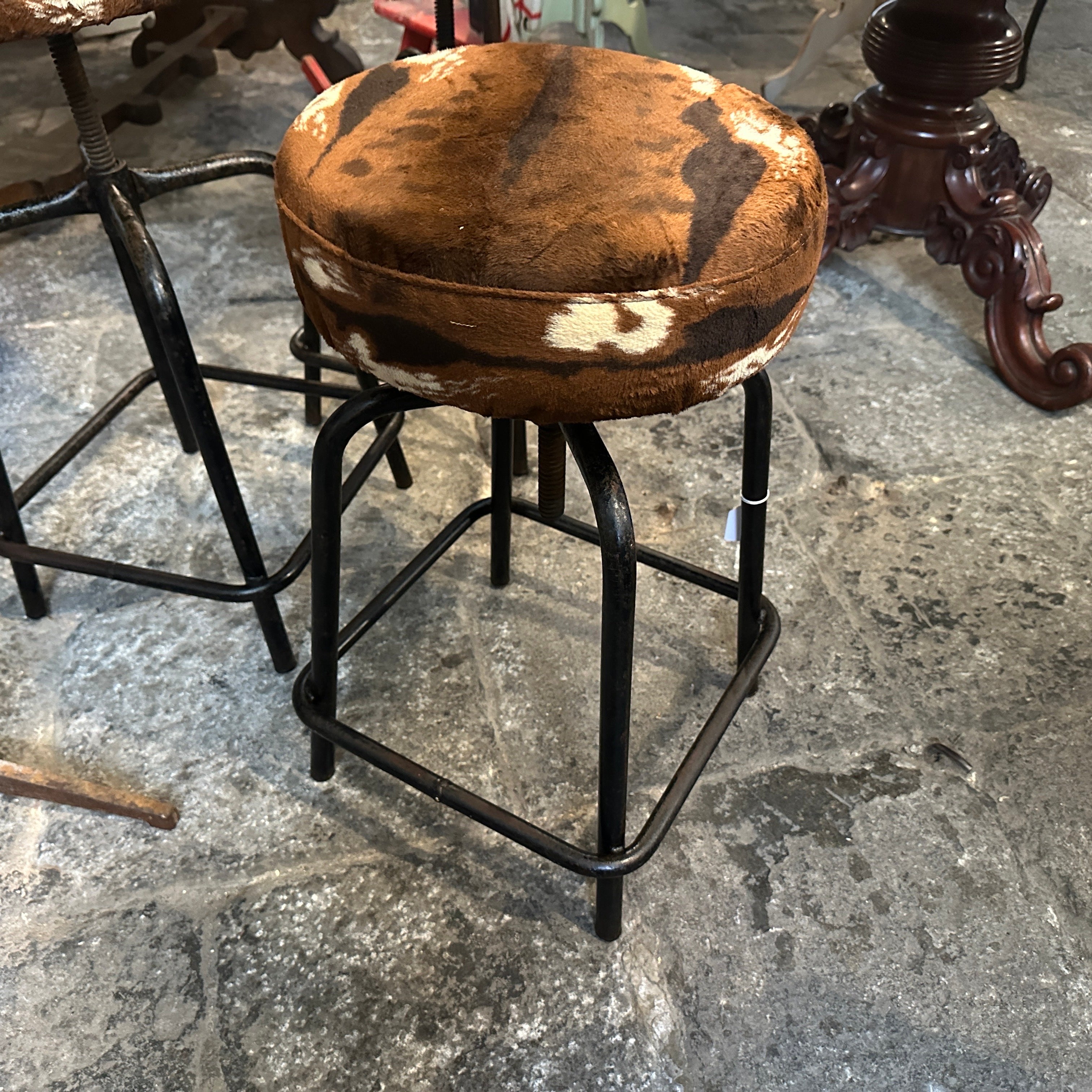 Se trata de tres reposapiés industriales italianos de los años 50, de altura regulable y diseño robusto. Tienen robustos armazones de hierro, con patas que se ensanchan ligeramente para mayor estabilidad, y reposapiés integrados en su diseño. Los