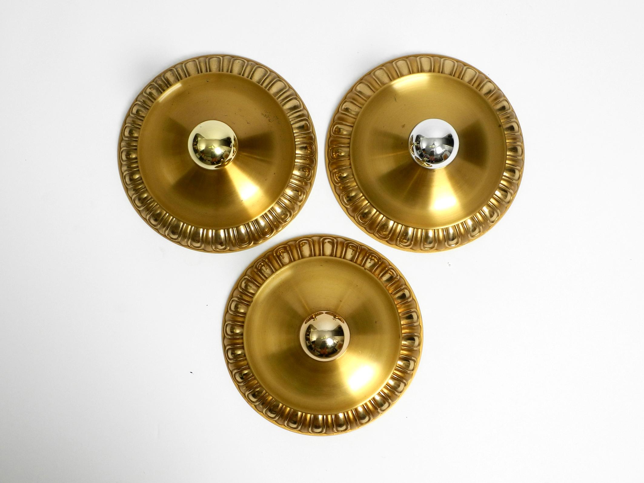 Three fancy 60's space age pop art round wall or ceiling lamps.
Manufacturer is Sölken lights. Made in Germany.
The outer ring is made of brass. The back is in white and the middle part are made of metal. Fully functional with one E27 original metal